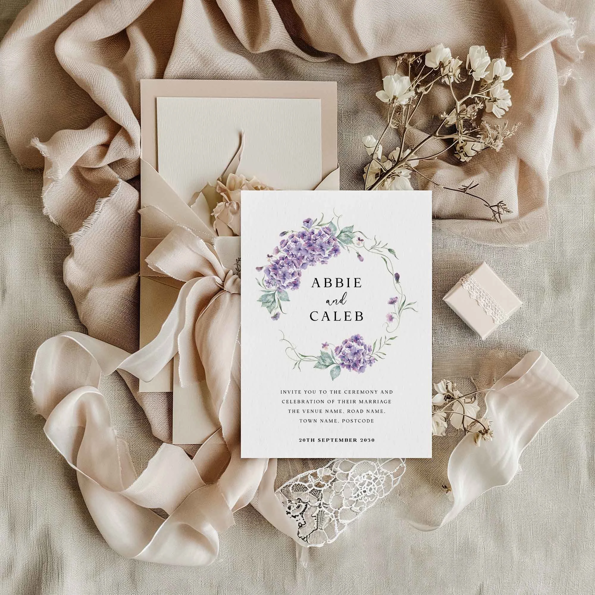 Purple Hydrangea wedding invitation styled in a flat lay environment with wedding props