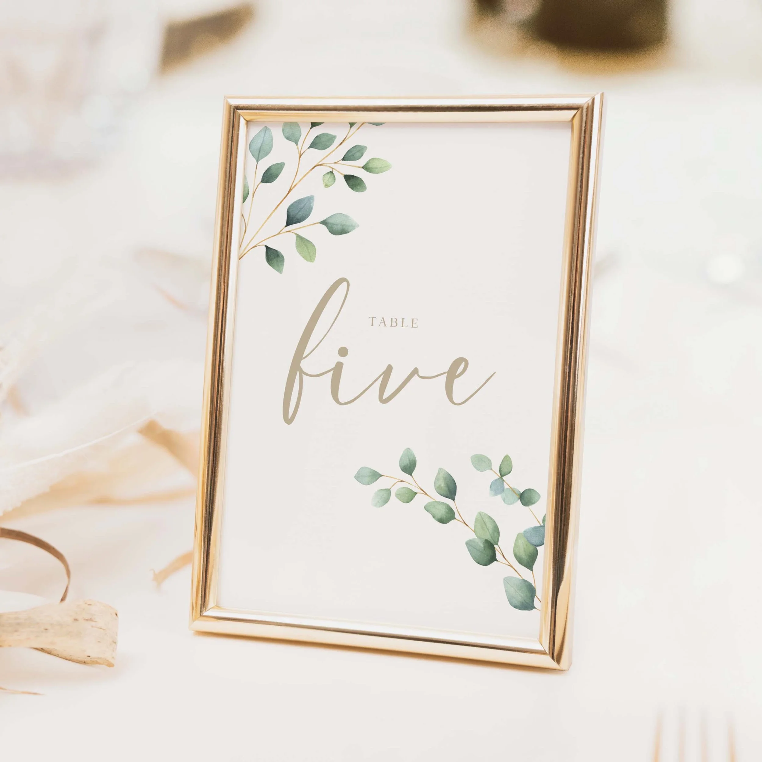 Eucalyptus Foliage Calligraphy wedding table number with botanical eucalyptus border and flowing calligraphy script typography on luxury off-white card