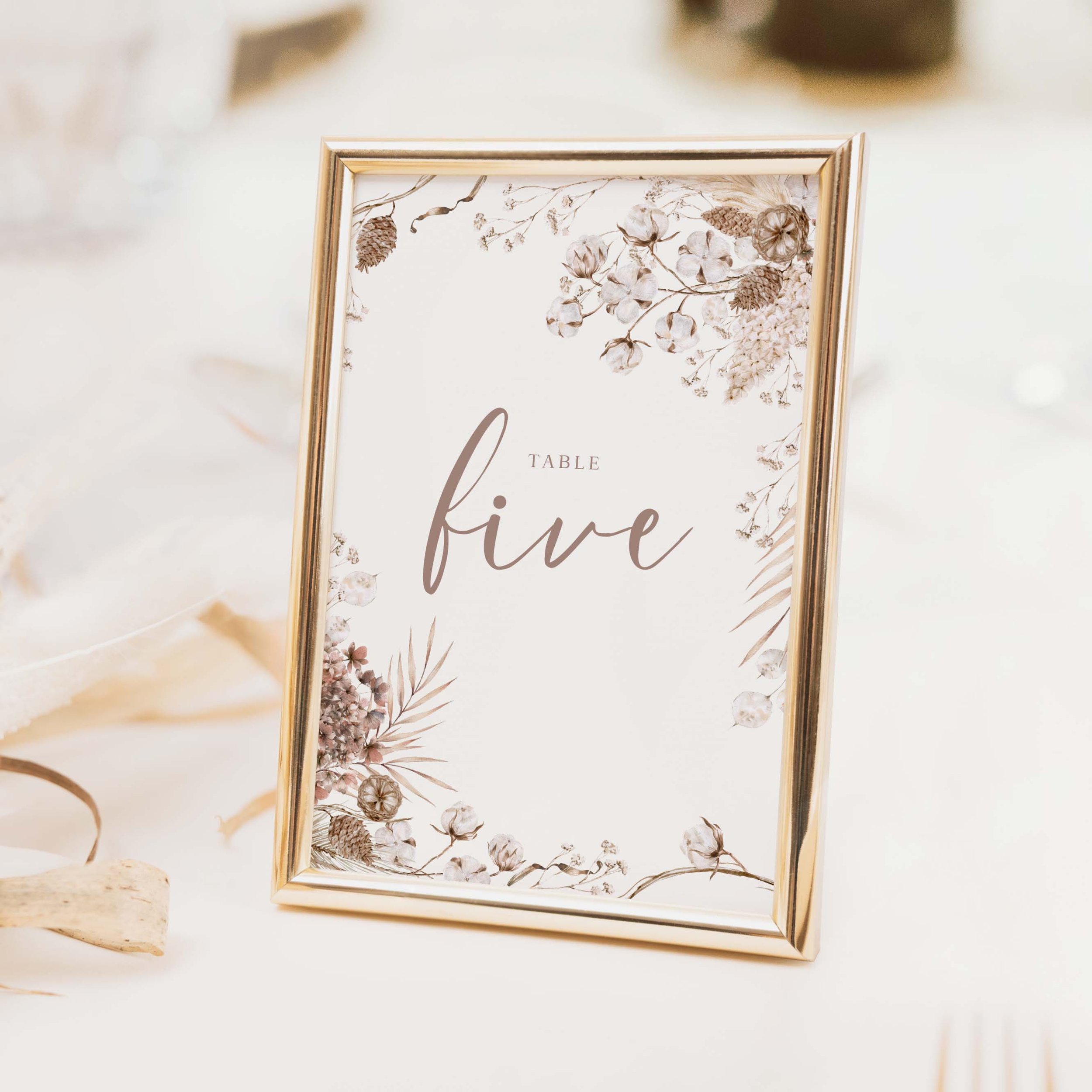 Boho wedding table number with warm neutral tones and flowing loose script typography in relaxed bohemian style printed on luxury off-white textured card
