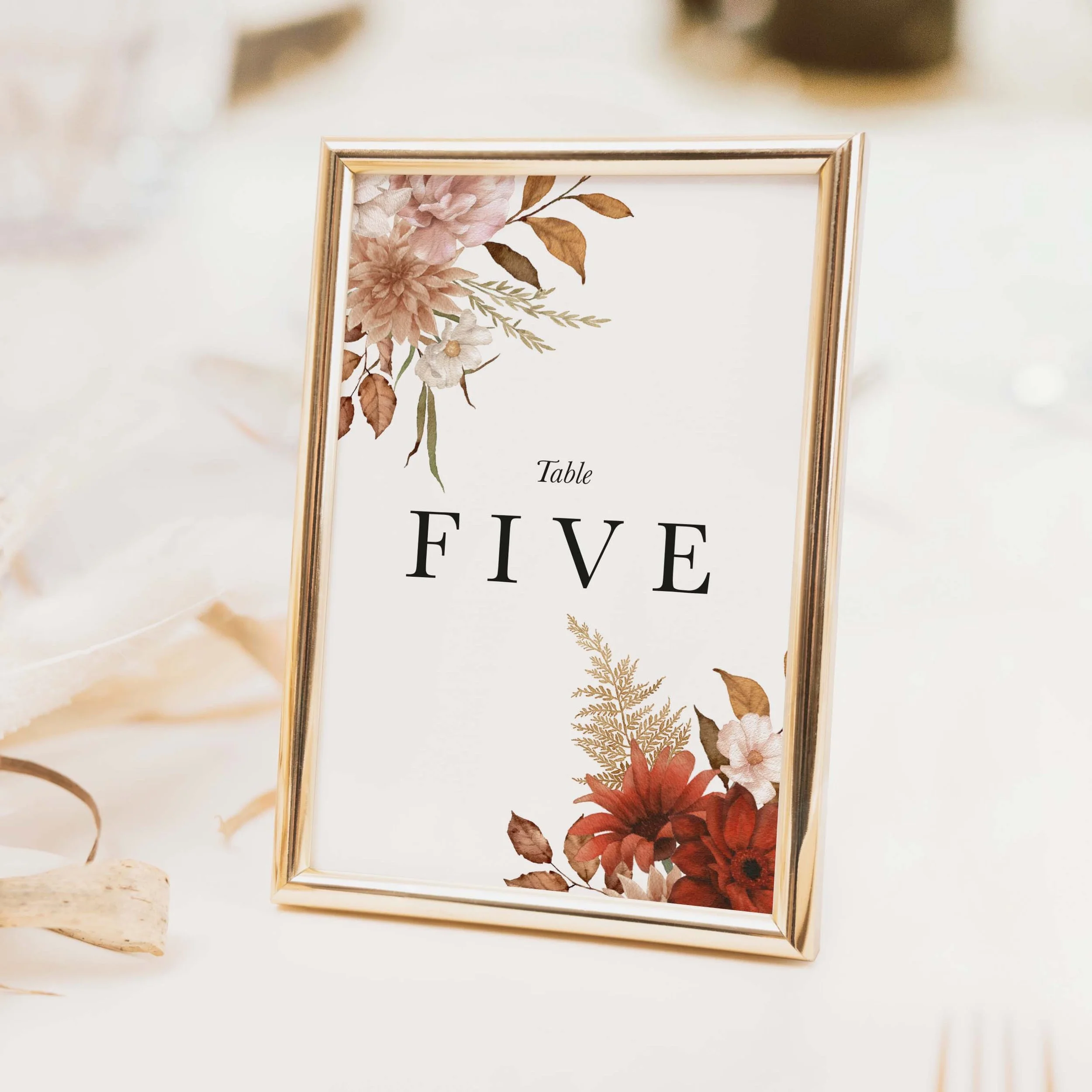 Rustic wedding table number with burnt orange terracotta and warm autumn floral arrangement and clean typography on luxury off-white card