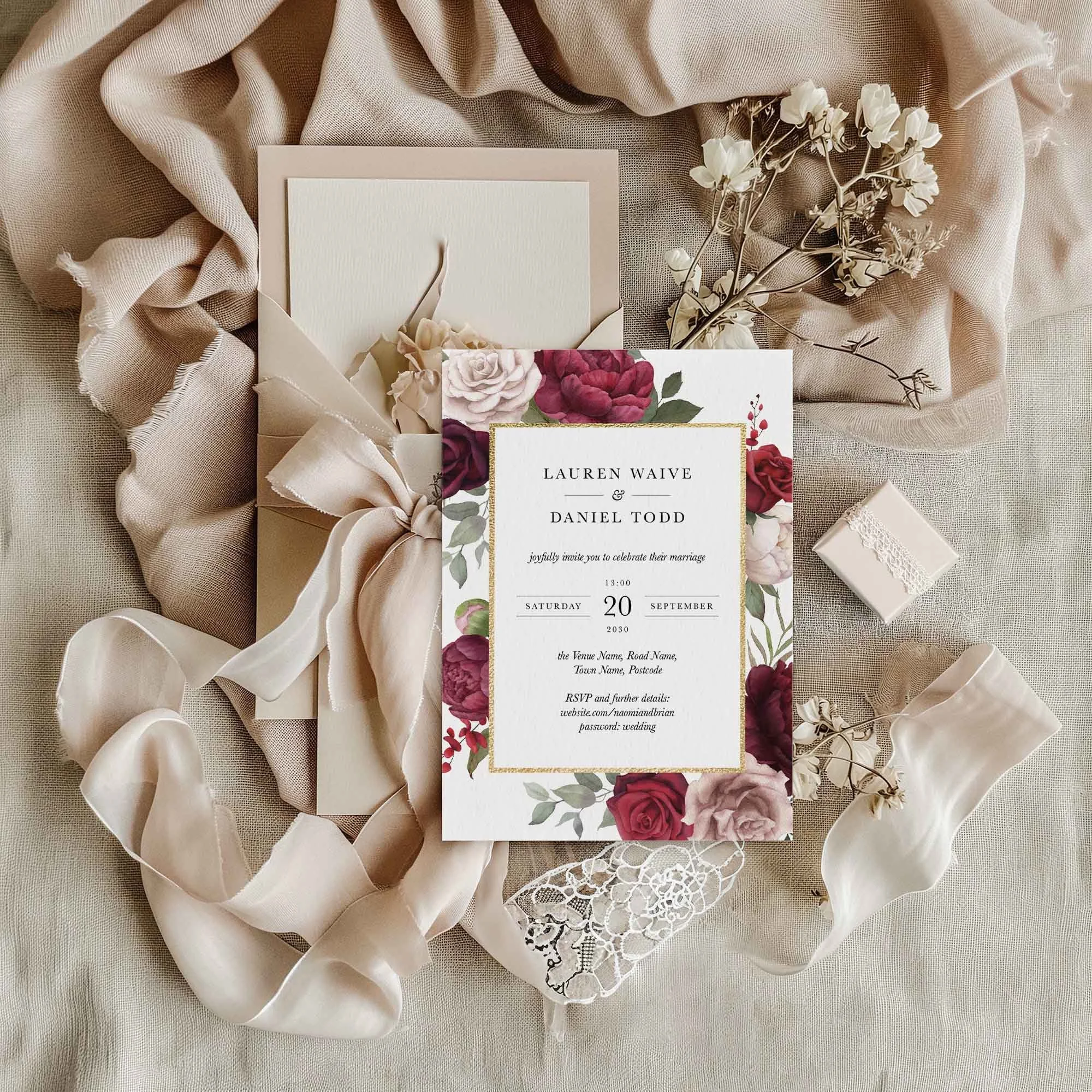 Burgundy and Blush Floral wedding invitation styled in a flat lay environment with wedding props