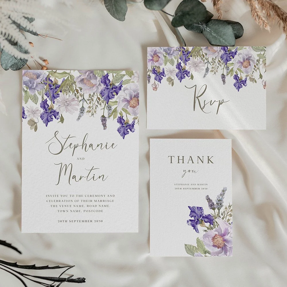Save the date card with a soft purple floral wreath of lilac and violet flowers, including irises, in a romantic and elegant watercolour style.