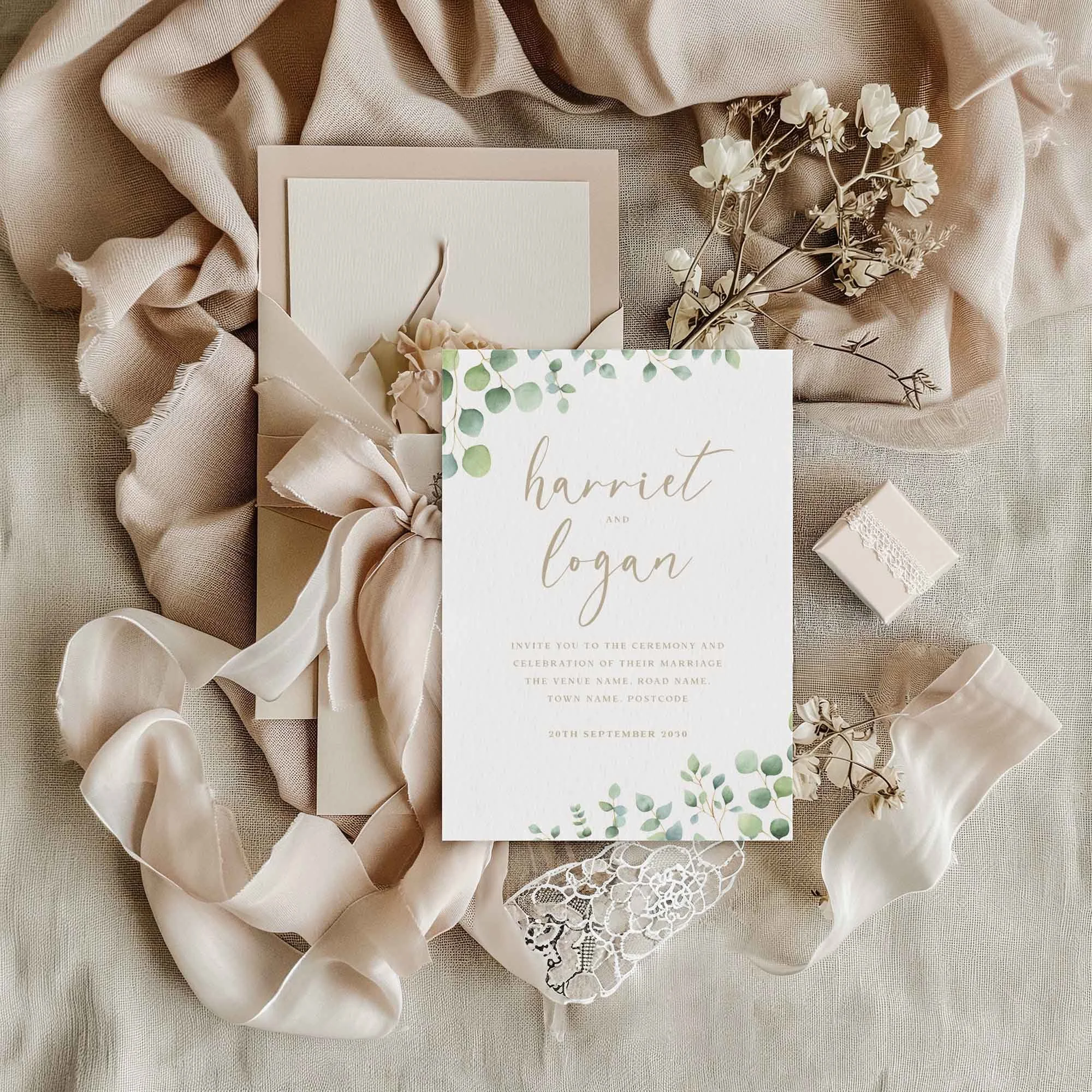 Eucalyptus Calligraphy wedding invitation styled in a flat lay environment with wedding props