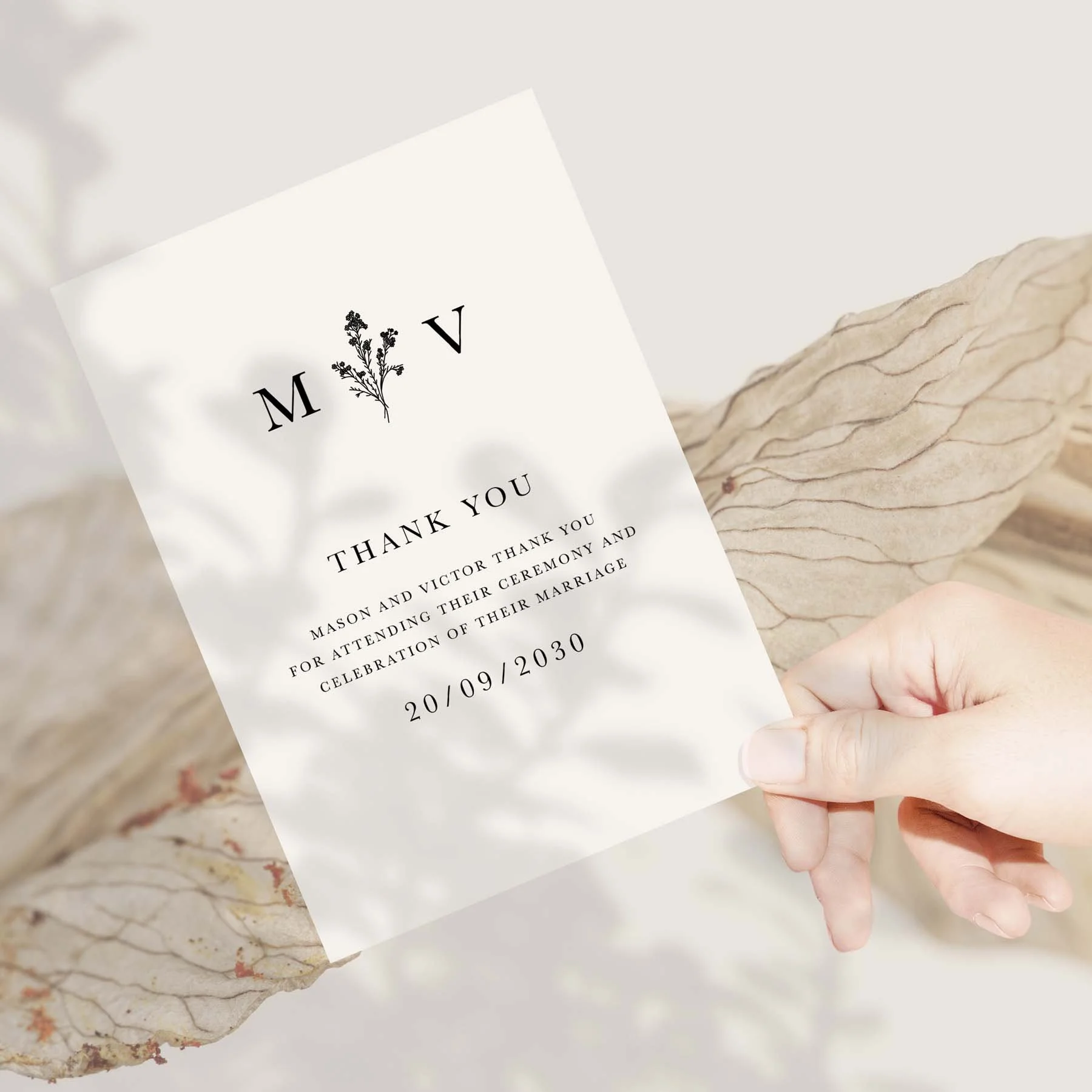 Hand holding a Monogram wedding thank you card
