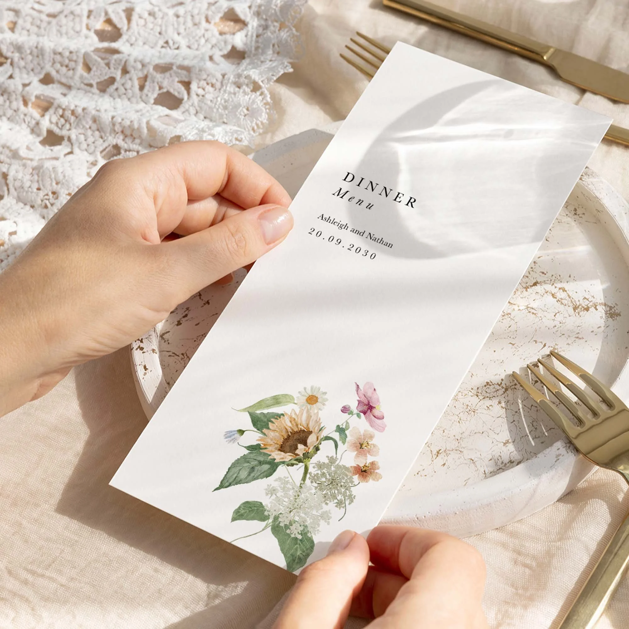 Hand holding an Autumn Sunflower wedding breakfast menu card with a sunflower and mixed wildflower botanical illustration
