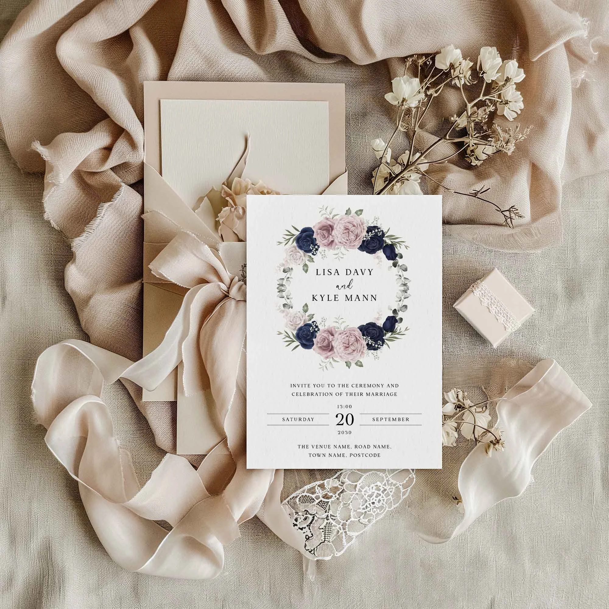 Blue and Pink Wreath wedding invitation styled in a flat lay environment with wedding props