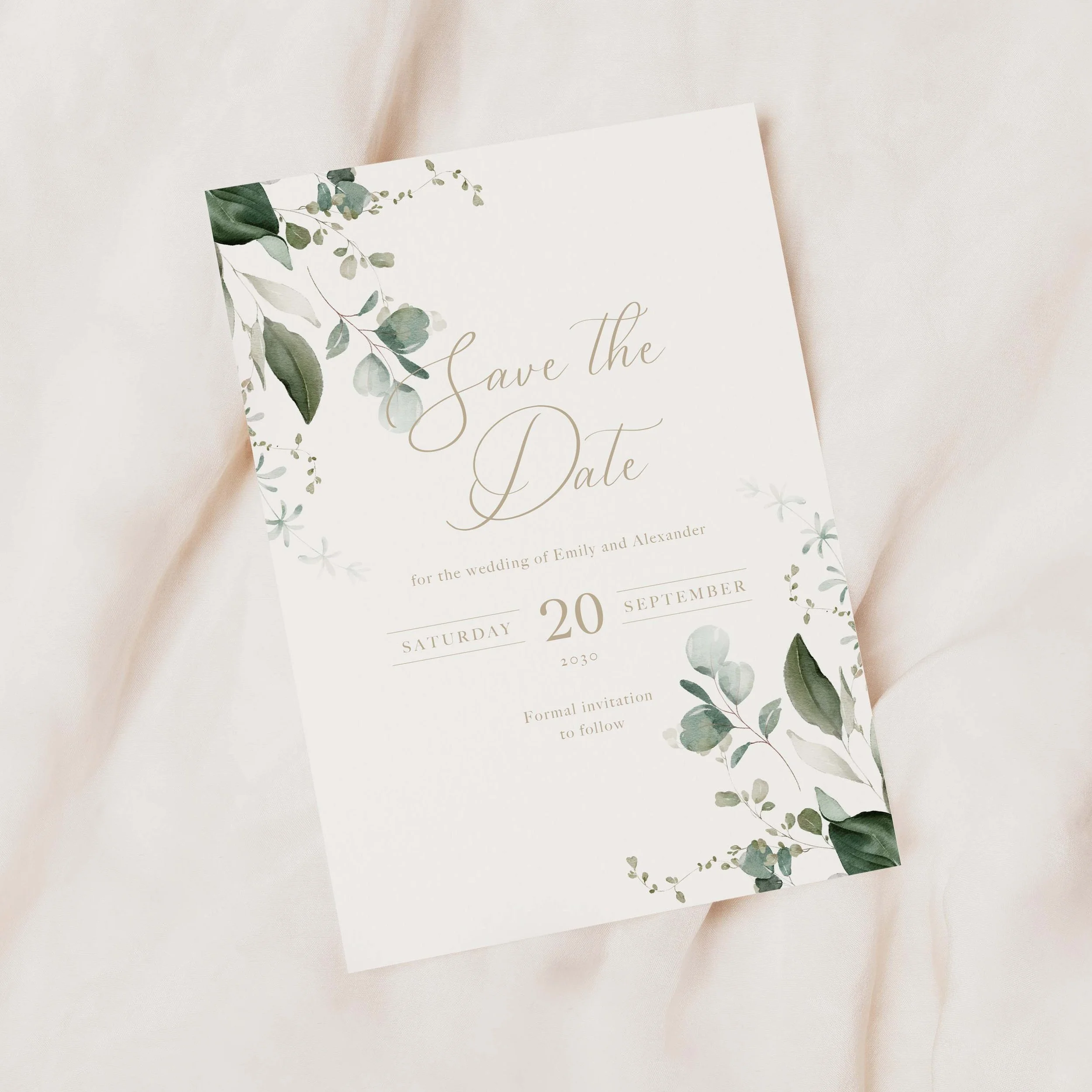 Wedding save the date card featuring green foliage and gold typography