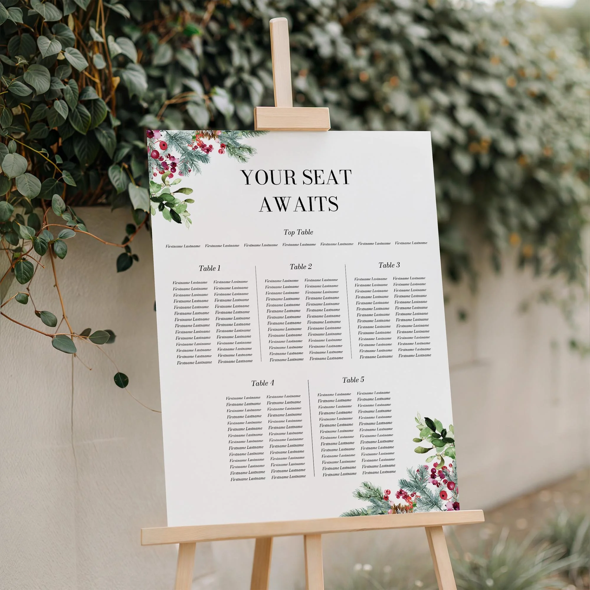 Festive wedding seating plan displayed on a wooden easel, featuring a holly and red berry Christmas botanical design with multiple guest tables