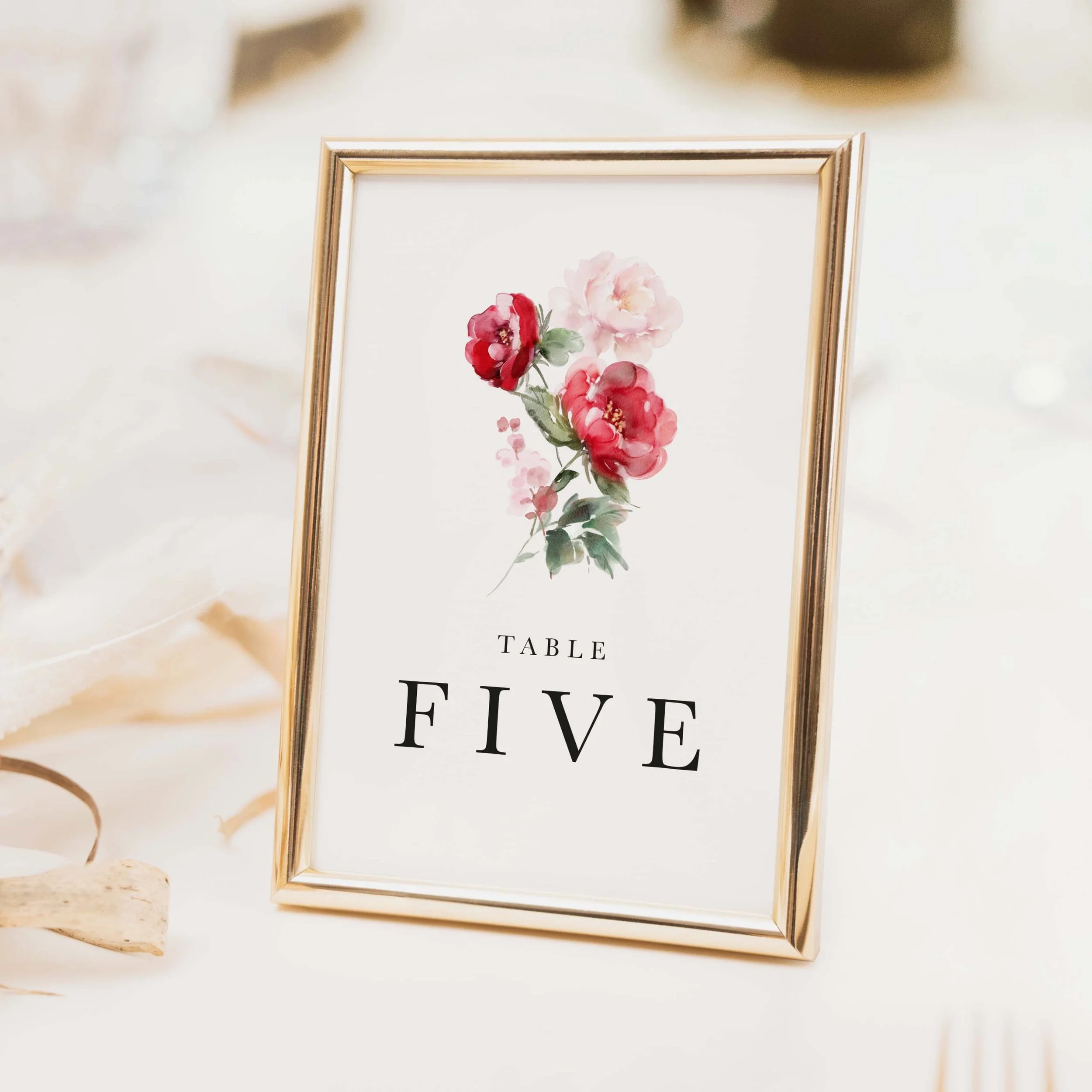 Red Floral wedding table number with rich red and pink rose bouquet arrangement and bold table typography on luxury off-white card