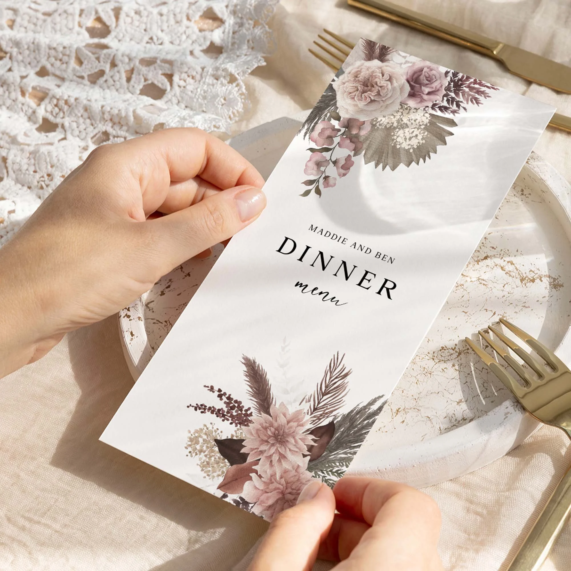 Hand holding a Blush Boho wedding breakfast menu card with pampas grass and dusty rose floral corner illustration
