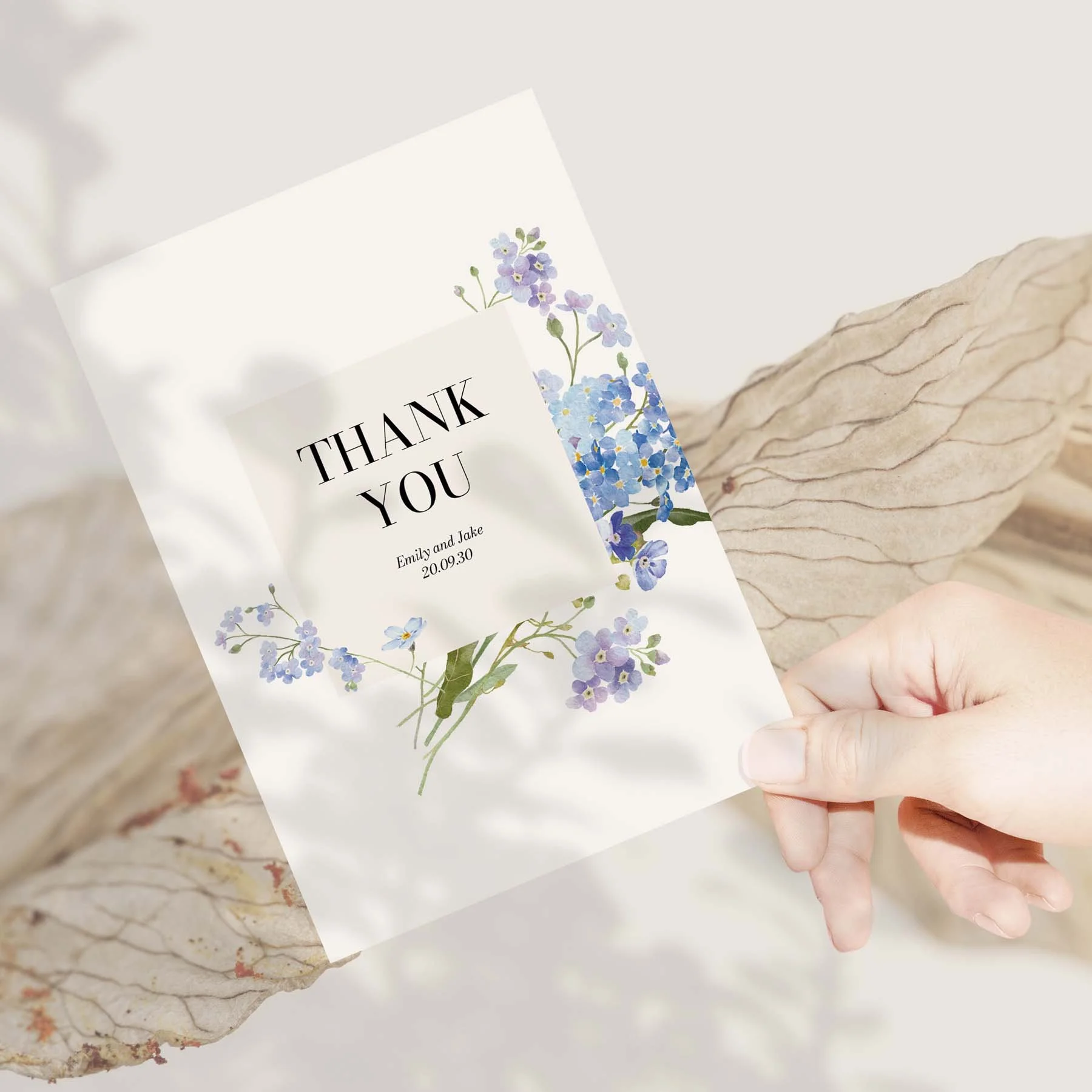 Hand holding a Forget Me Not wedding thank you card