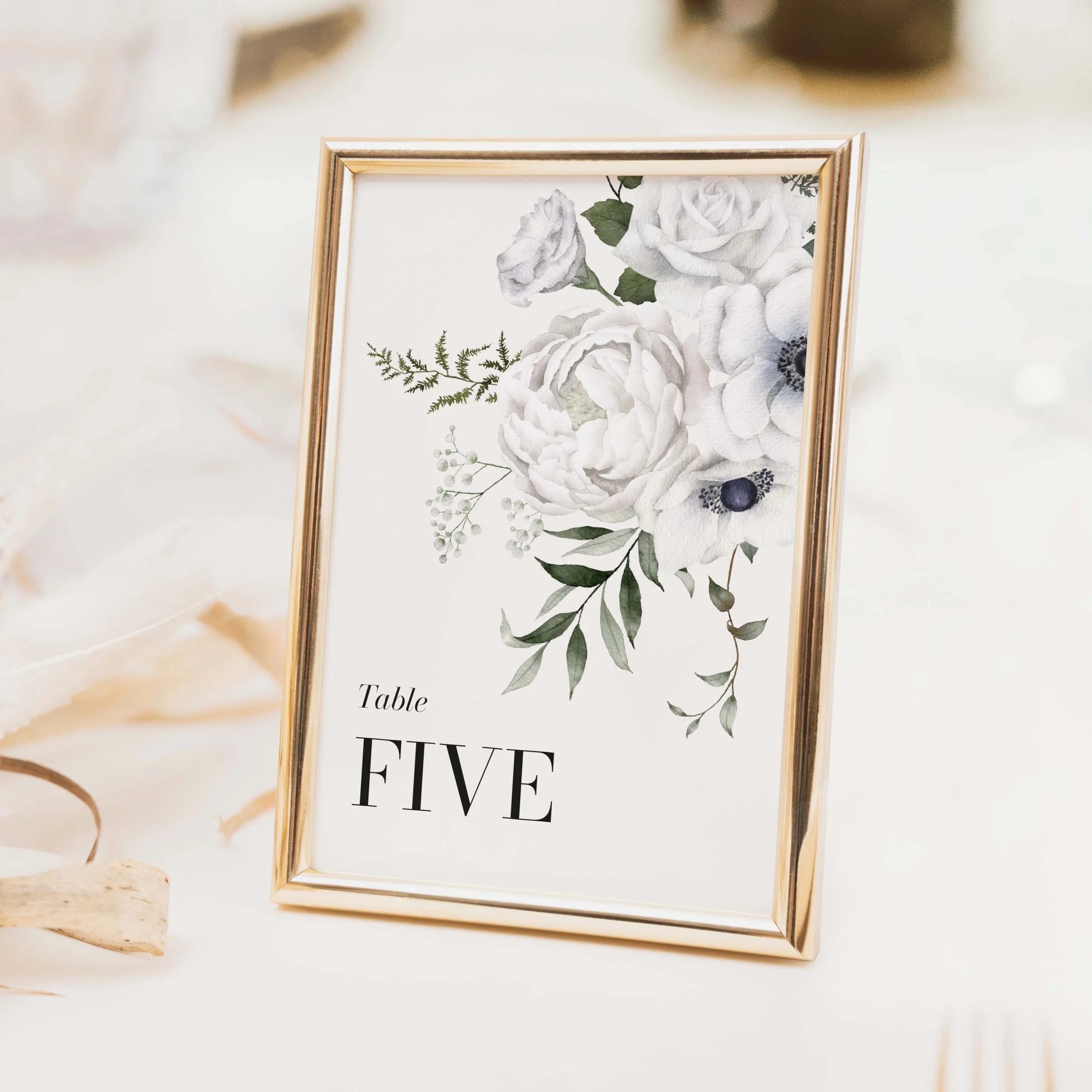 White Floral wedding table number with delicate white and green botanical floral illustration and modern typography on luxury off-white textured card