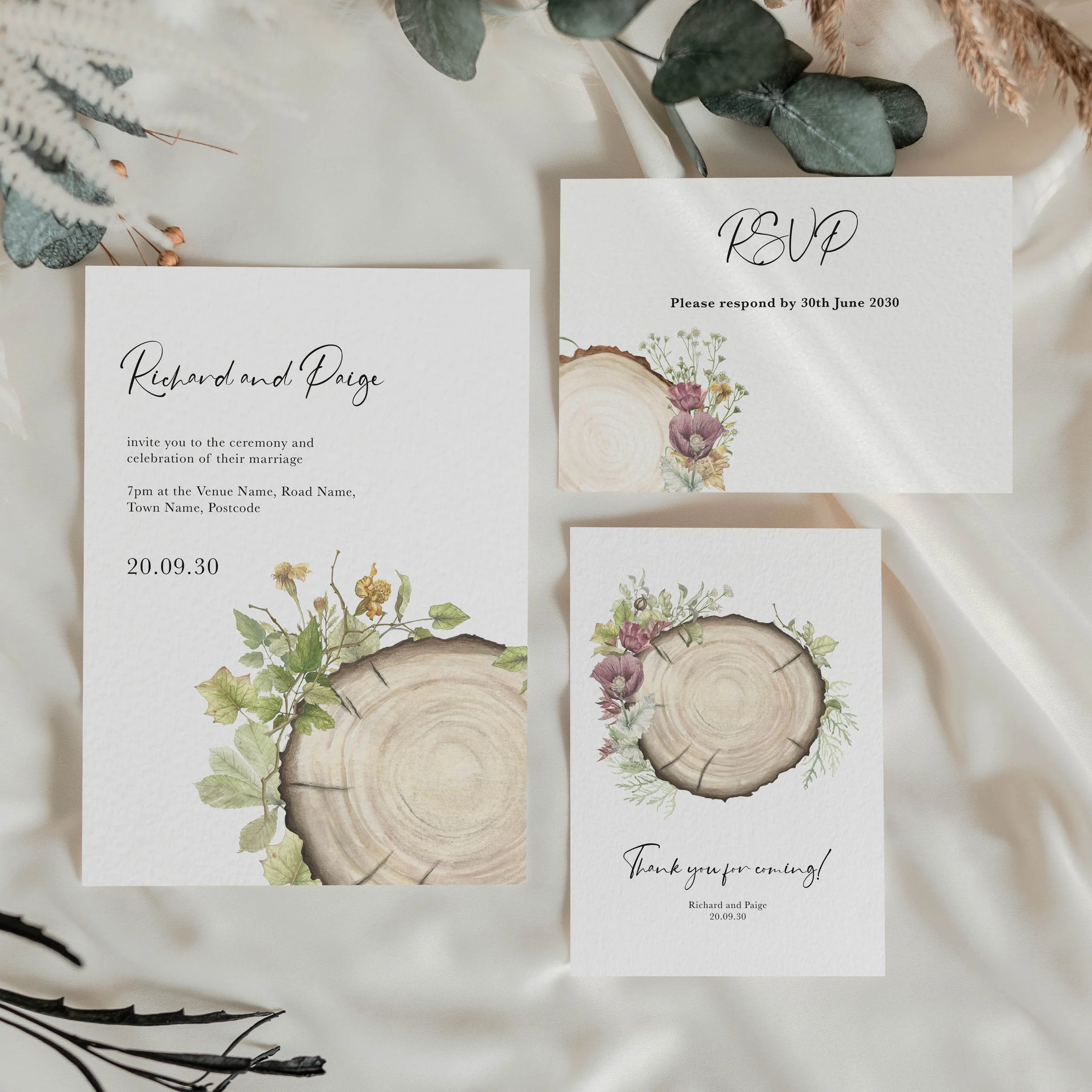 Wedding stationery suite featuring illustrations of a wood slice and rustic foliage in a watercolour style