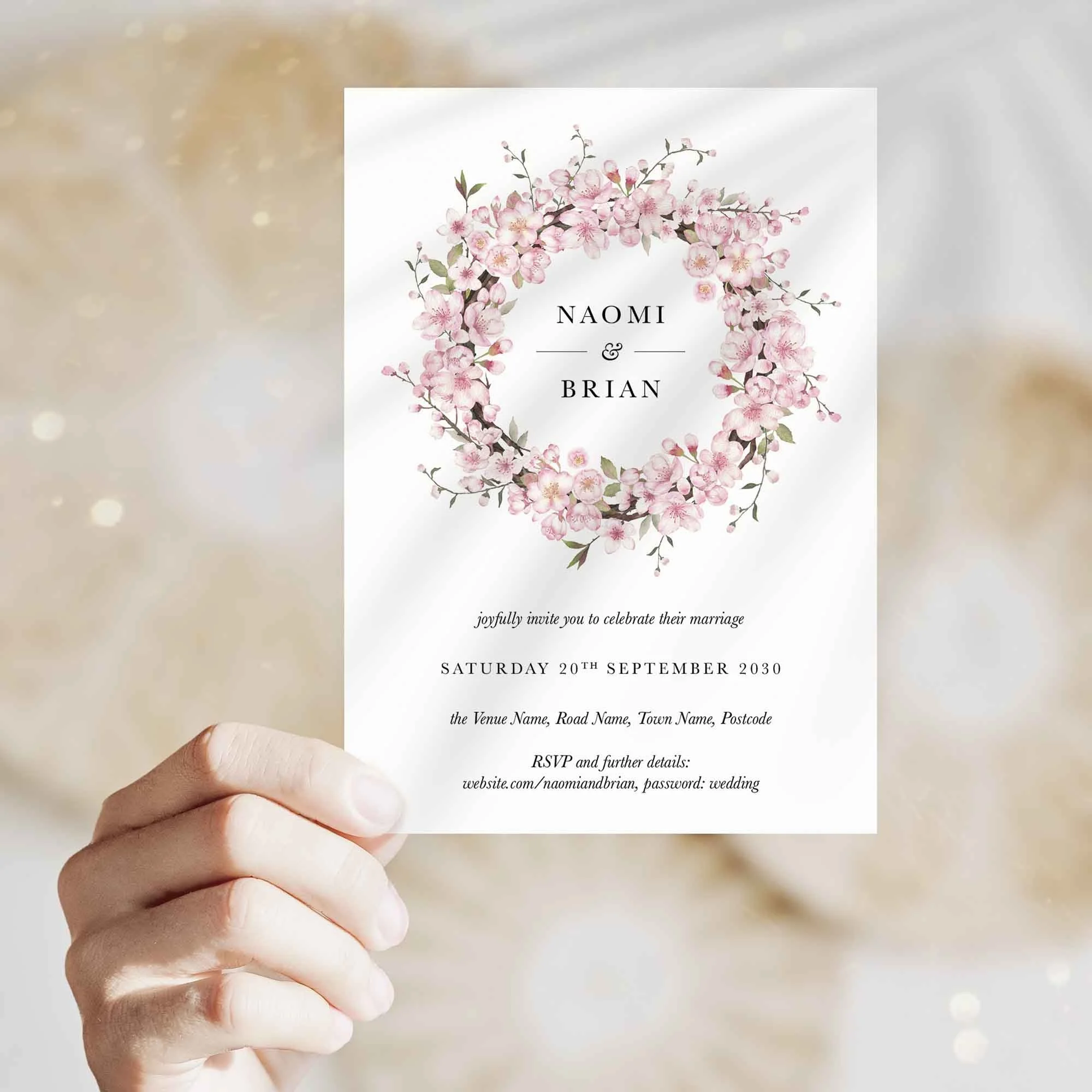Hand holding Cherry Blossom Wreath wedding invitation showing size and printed design details