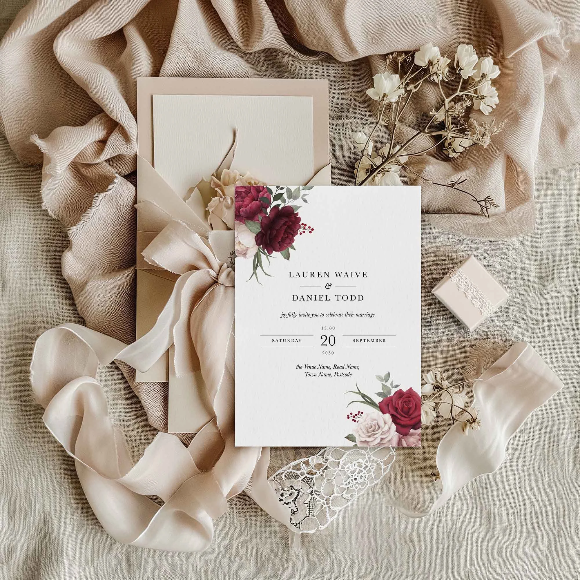 Pink and Burgundy Floral wedding invitation styled in a flat lay environment with wedding props