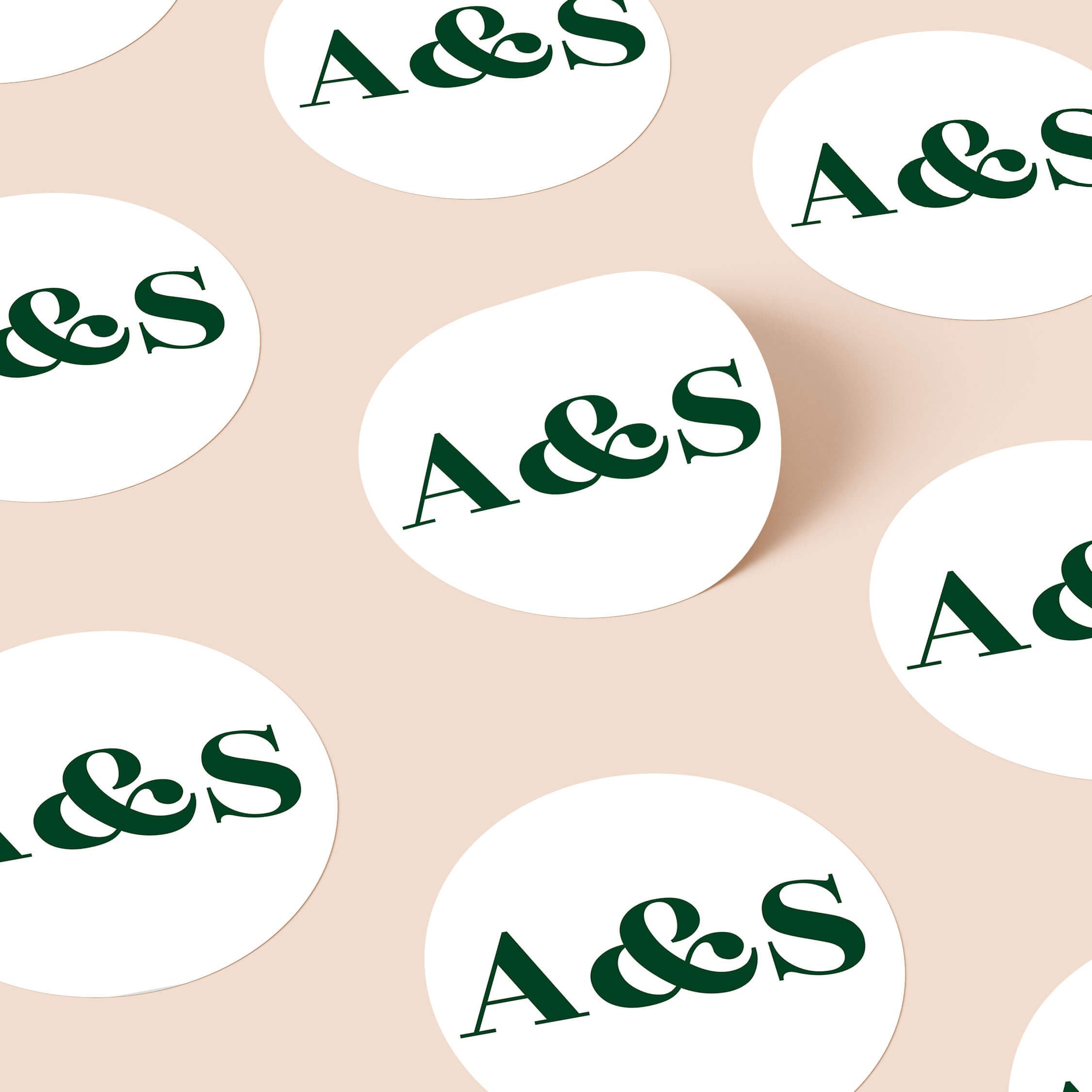 Personalised round wedding stickers with bold green initials in minimalist typography design for modern wedding stationery