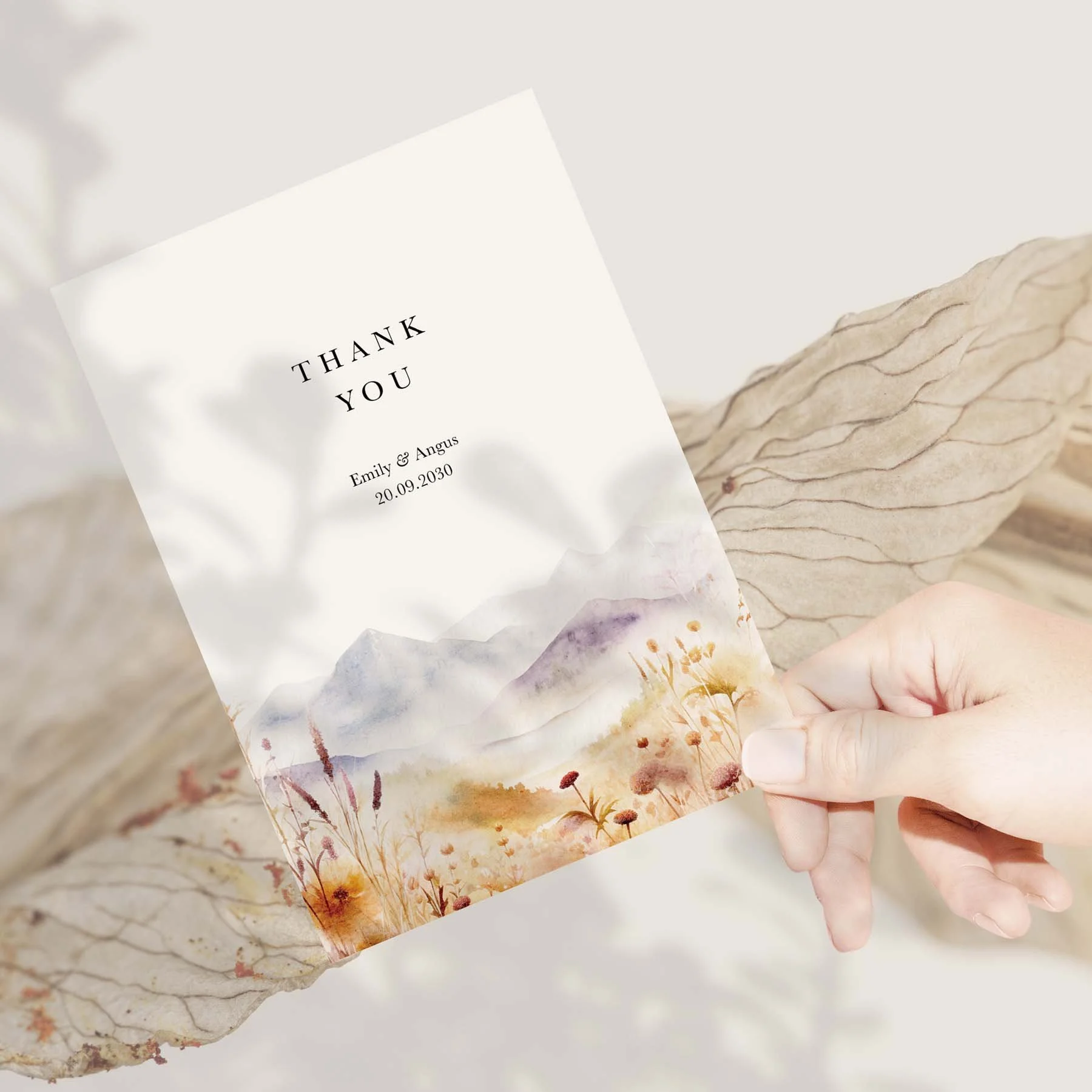 Hand holding a Fields and Mountains wedding thank you card
