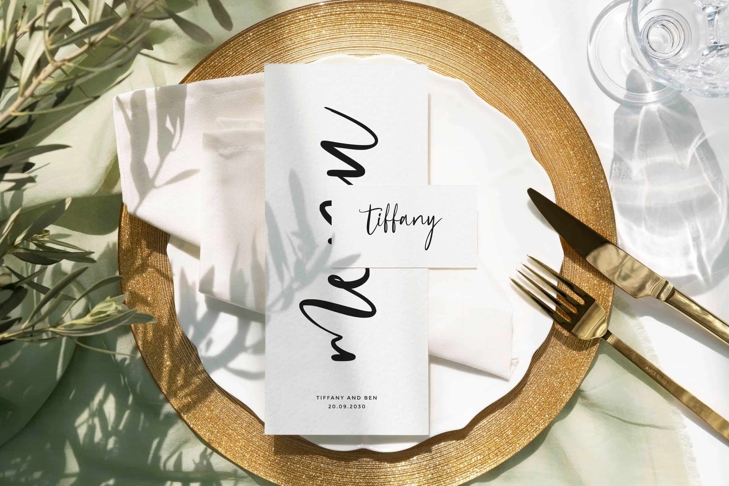 Elegant table setting with a gold-rimmed plate, white napkin, menu, name card reading 'Tiffany', and gold cutlery. Date: 20.09.2030.