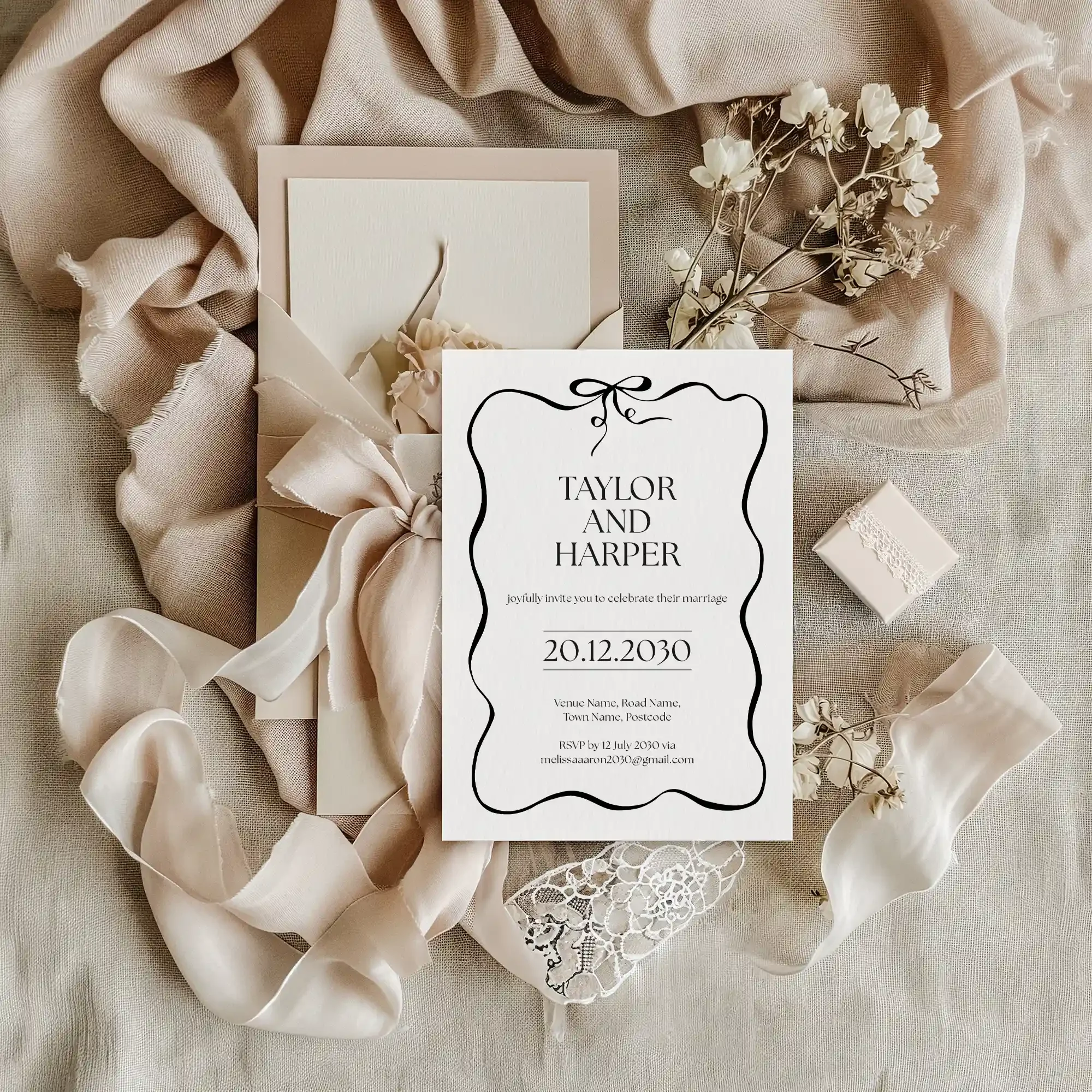 Black and white wedding invitation with bow motif and wavy border, styled on linen fabric with dried flowers and satin ribbon — Black Tie collection by Wonder Wedding Stationery