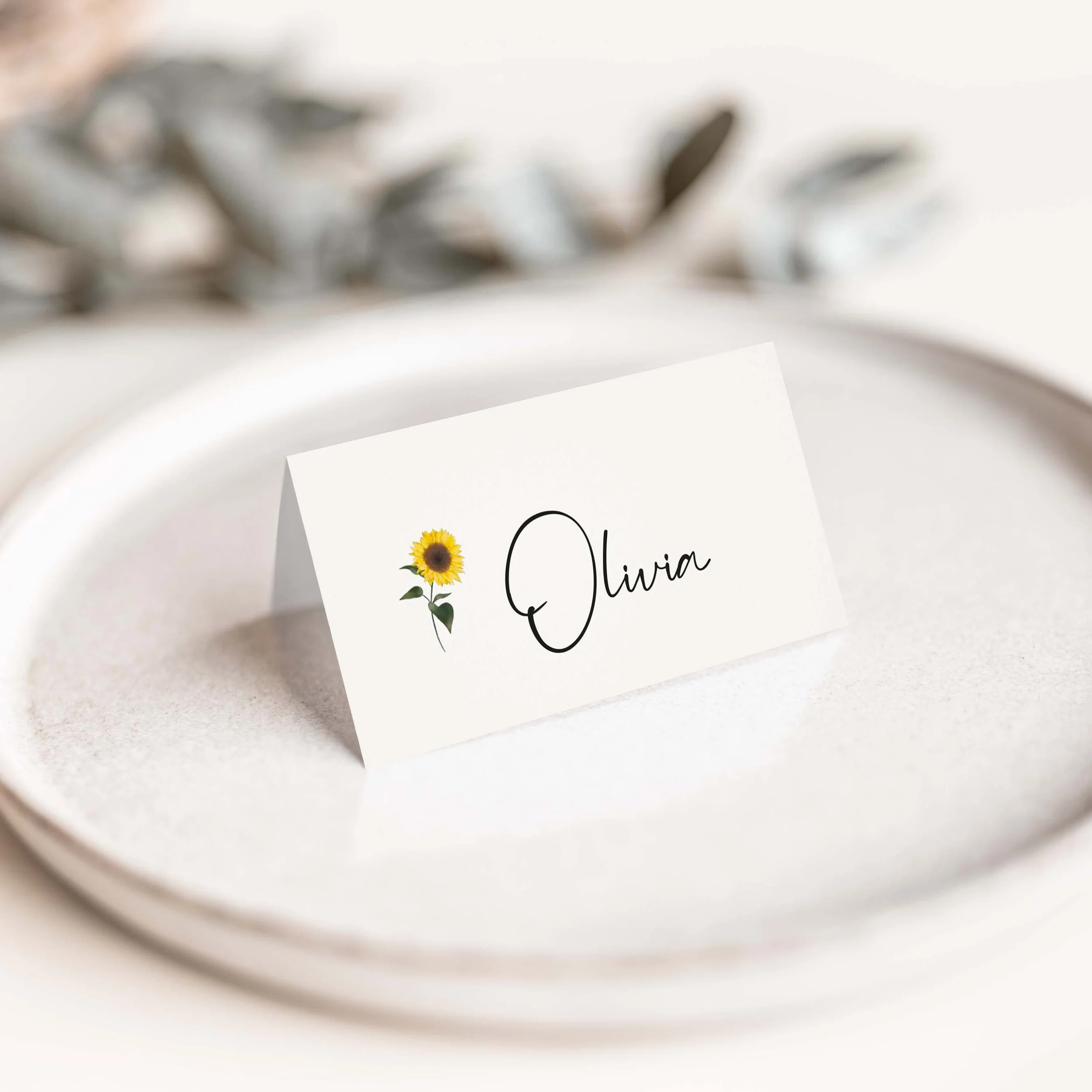 Sunflower wedding place card with delicate sunflower botanical illustration and flowing calligraphy script guest name on luxury off-white card