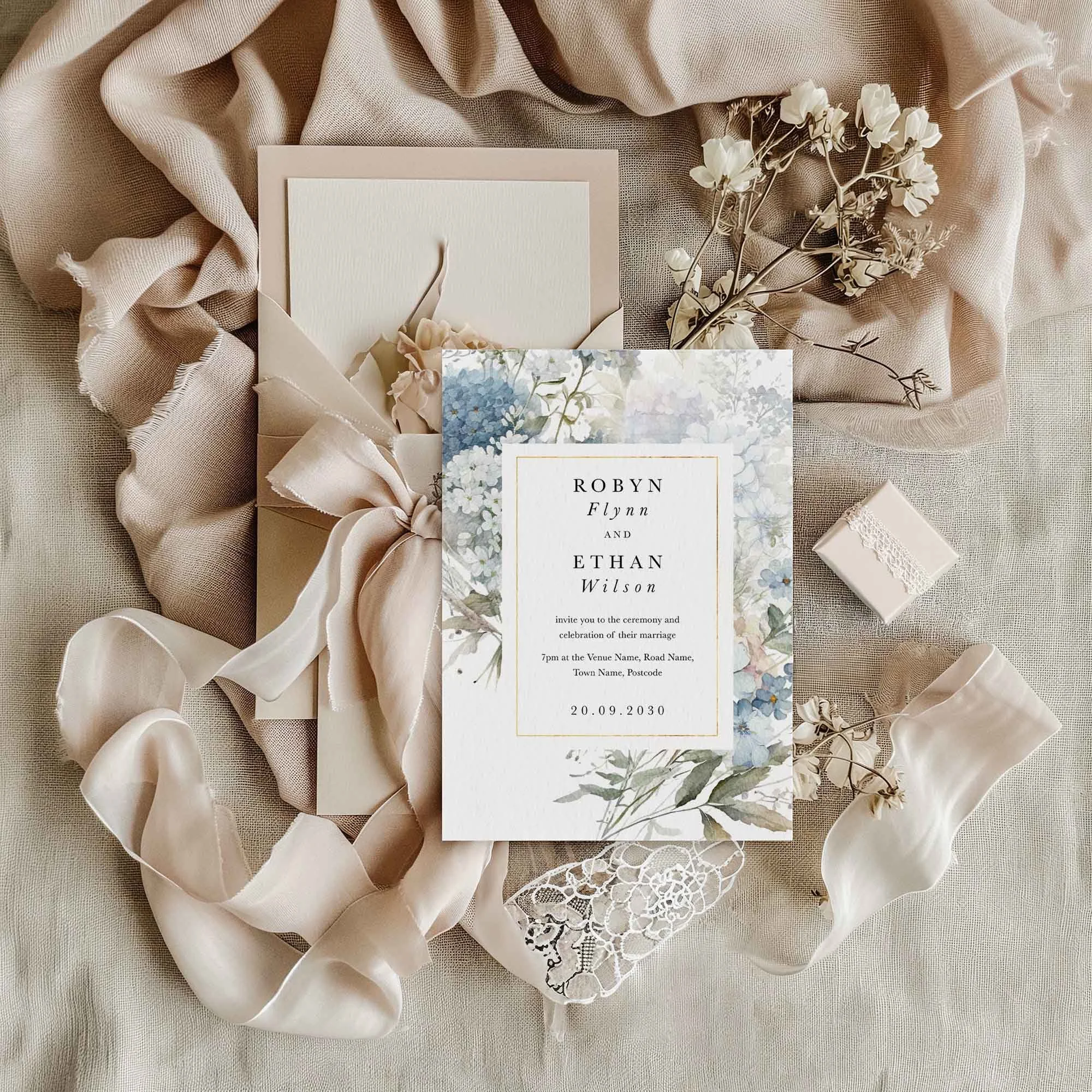 Dusty Blue wedding invitation styled in a flat lay environment with wedding props