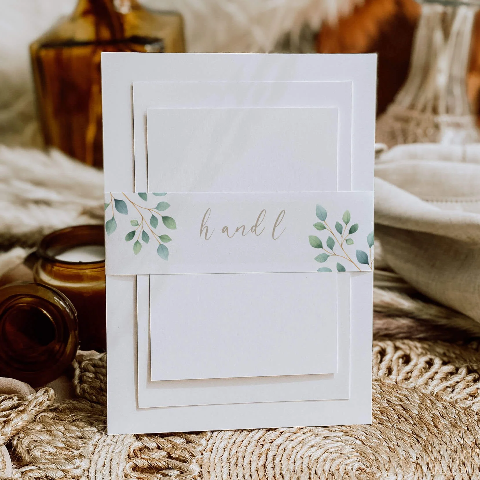 Eucalyptus Foliage Calligraphy personalised wedding belly bands with eucalyptus leaf illustration and handwritten script names wrapped around wedding invitations