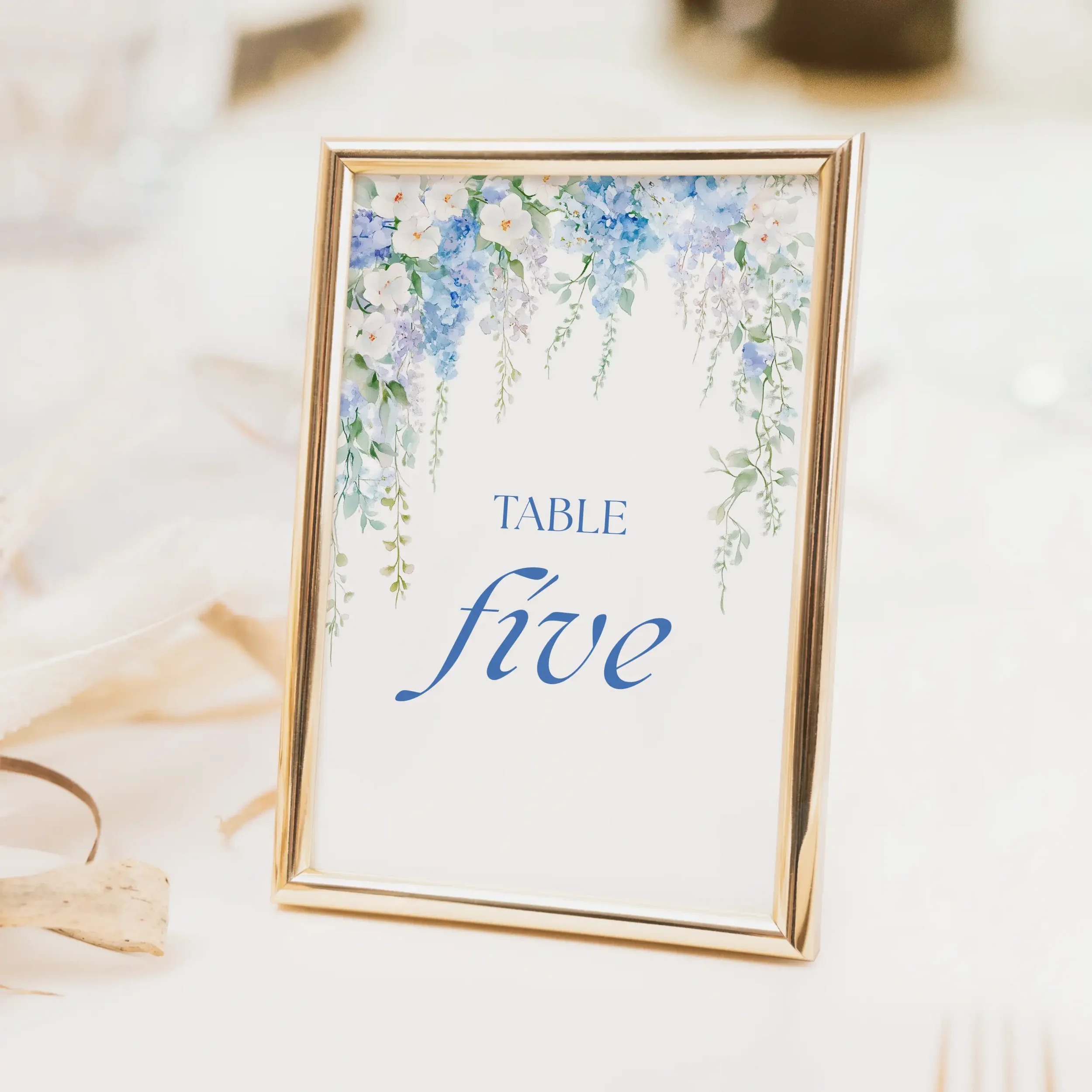Serenity wedding table number with hanging blue wisteria watercolour botanical illustration and clean table typography on luxury off-white card