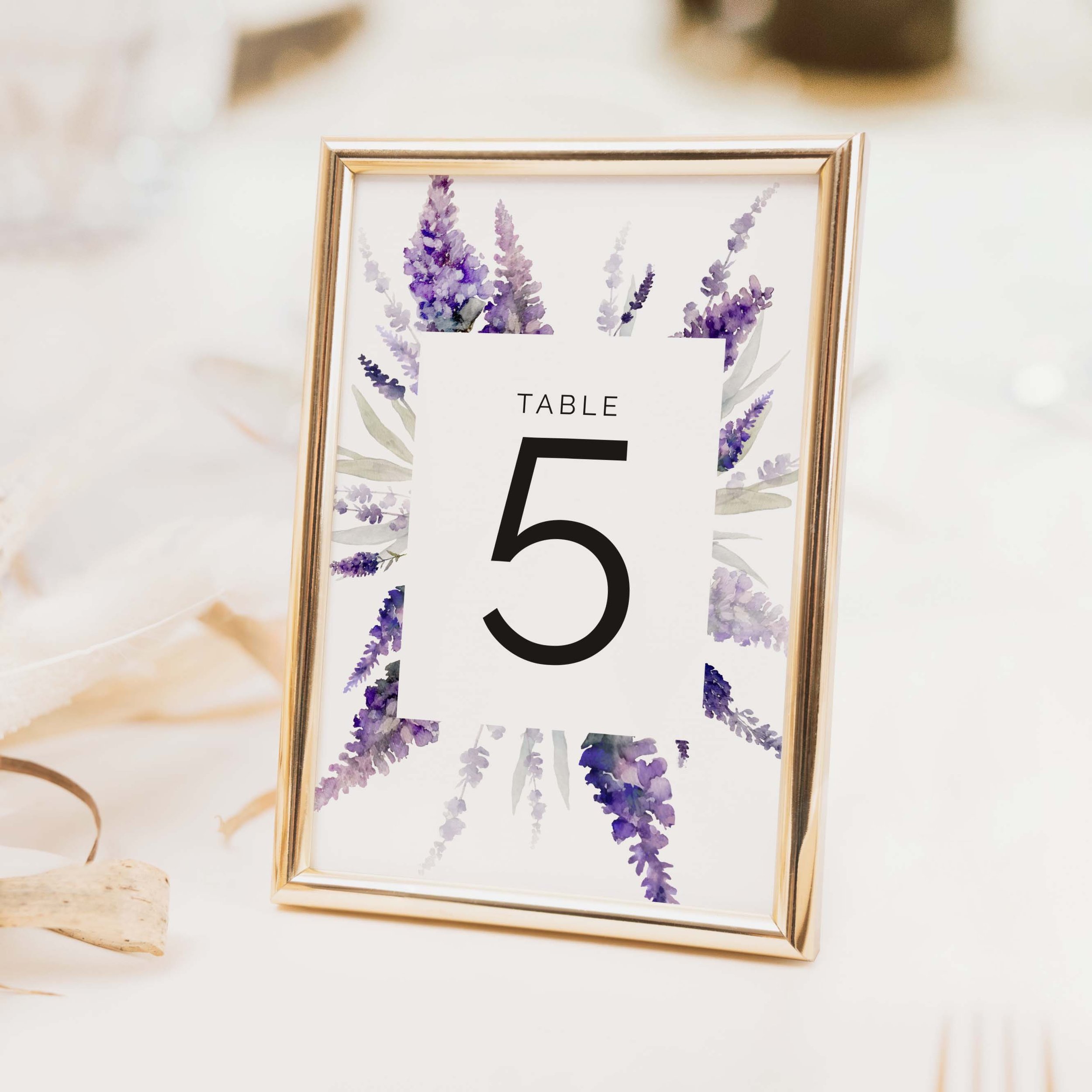 Lavender wedding table number with purple lavender stem botanical illustration and bold clean numeral on luxury off-white card