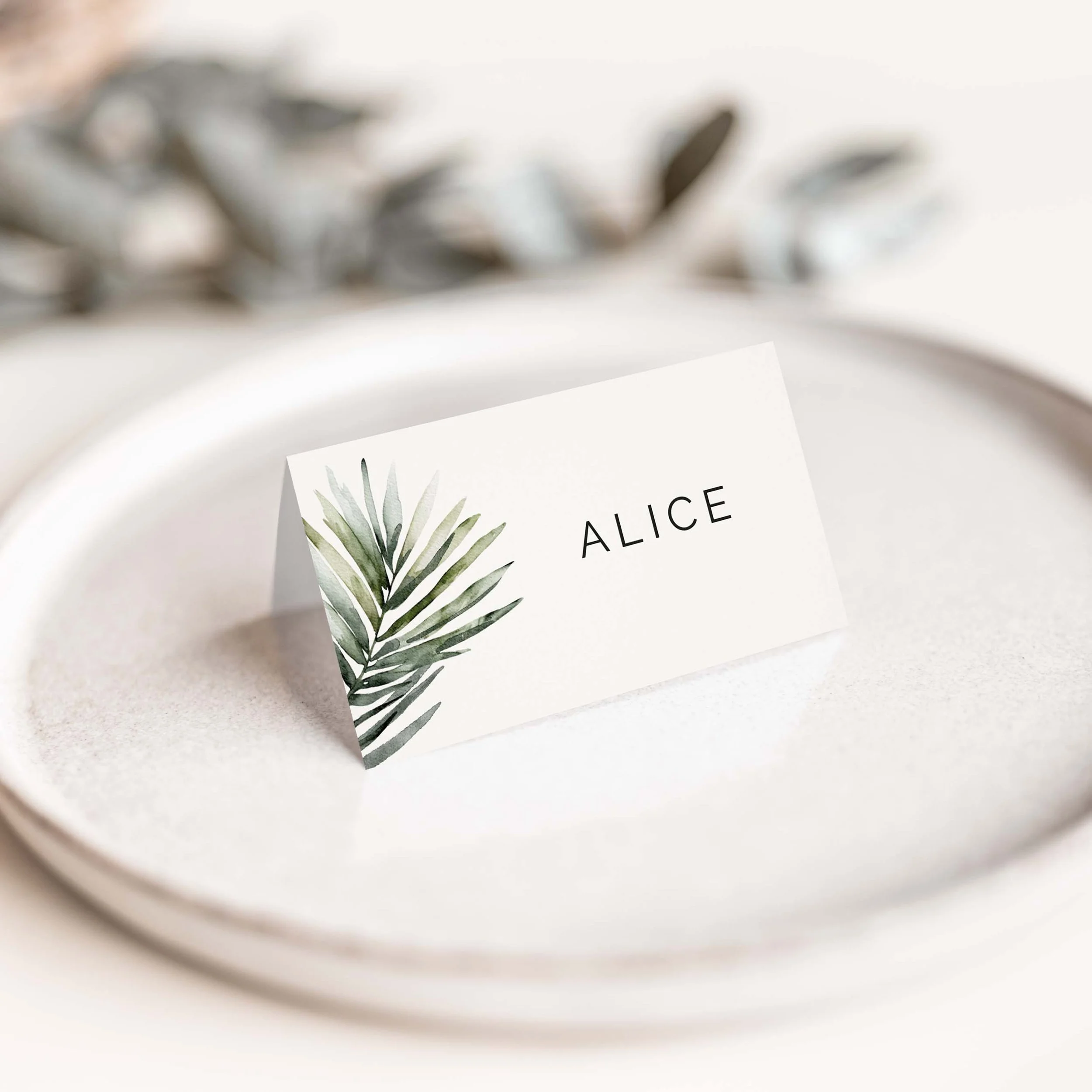 Palm leaf wedding place card with tropical greenery detail