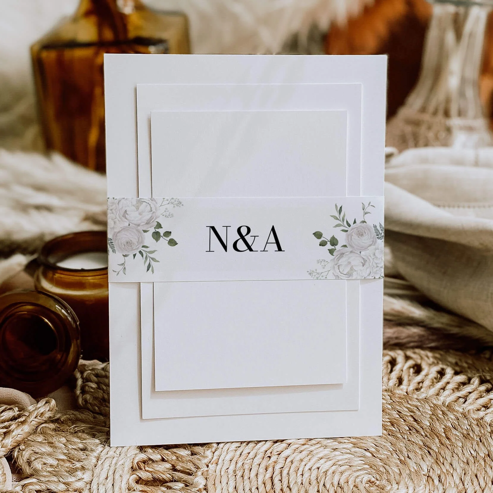 White Floral personalised wedding belly bands with white rose and eucalyptus watercolour illustration and serif initials wrapped around wedding invitations