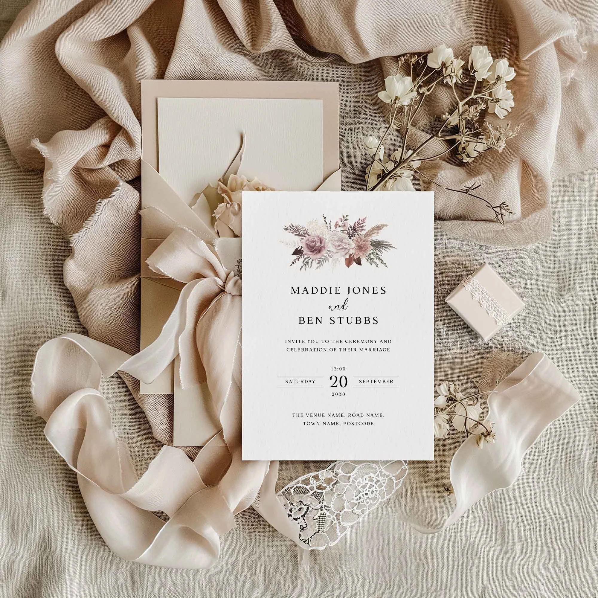 Pink Pampas wedding invitation styled in a flat lay environment with wedding props