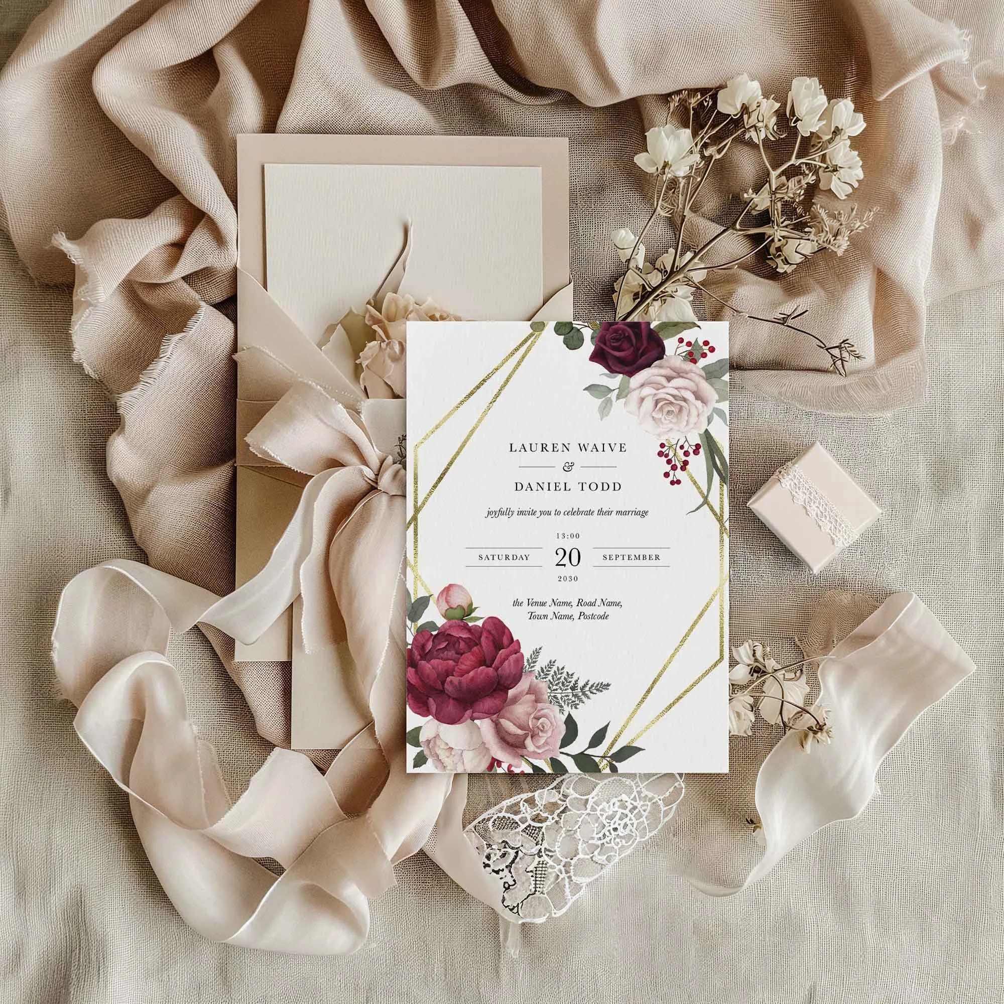 Pink and Burgundy Floral with Gold Frame wedding invitation styled in a flat lay environment with wedding props