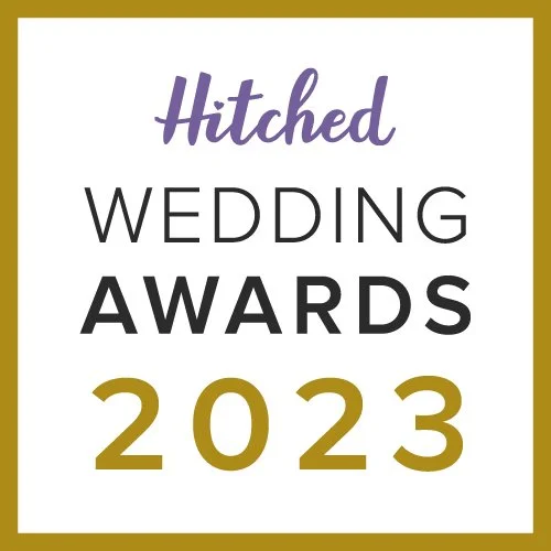 Logo for the Hitched Wedding Awards 2023, with purple script for "Hitched" and bold black and gold text for "WEDDING AWARDS 2023".