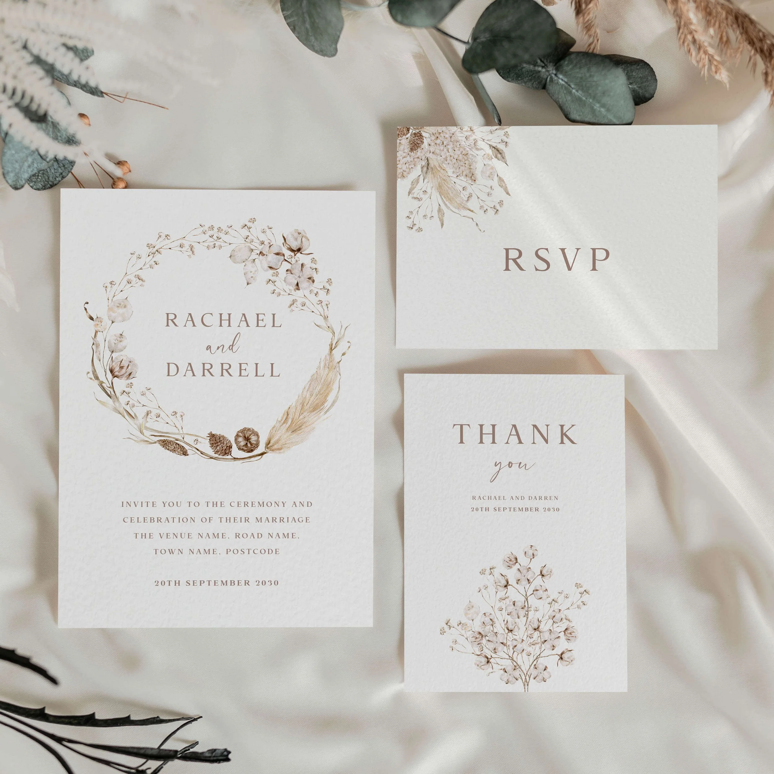 The Boho wedding stationery collection showing invitation and menu card with a neutral dried botanical wreath in warm ivory and taupe