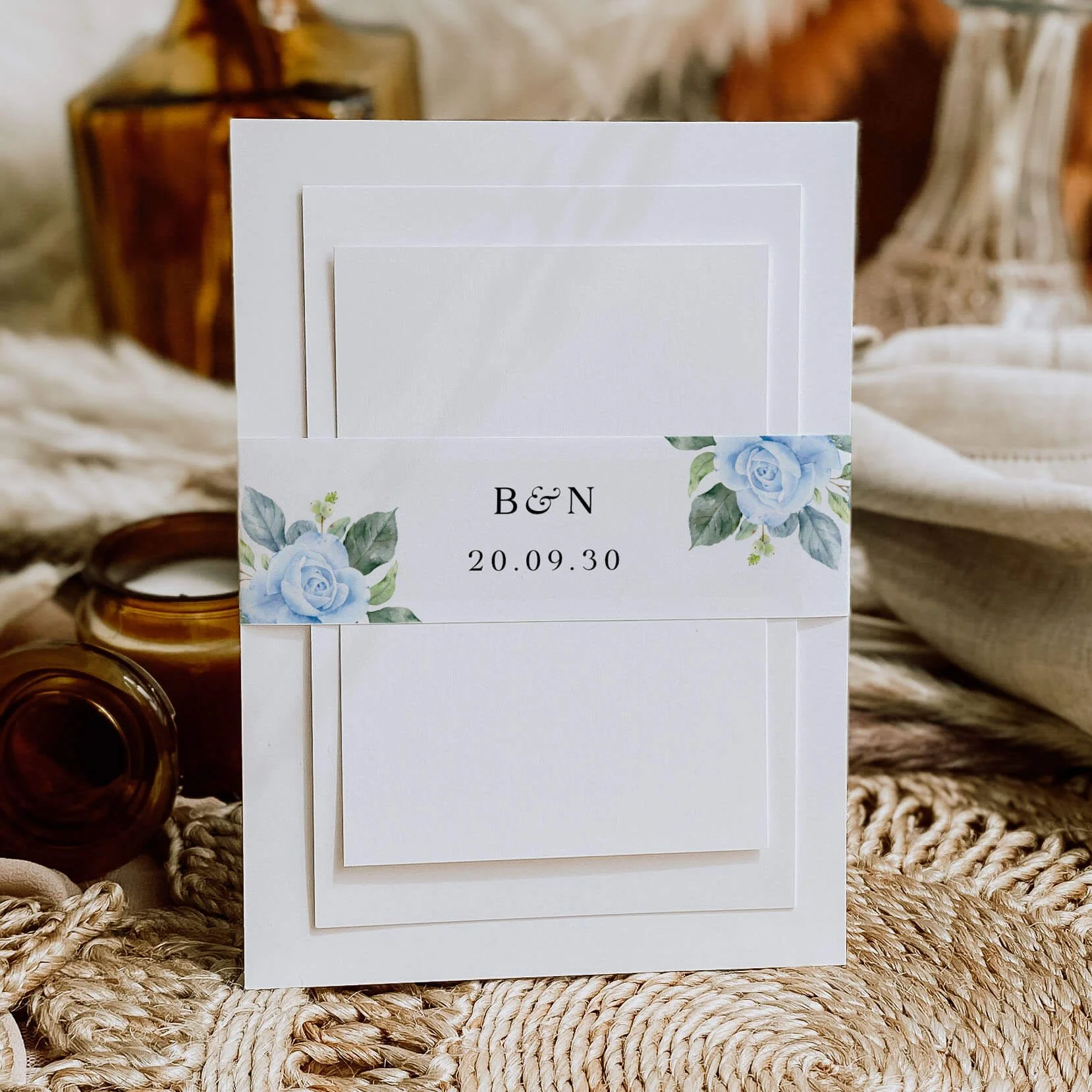 Blue Floral personalised wedding belly bands with watercolour blue rose and eucalyptus illustration wrapped around wedding invitations