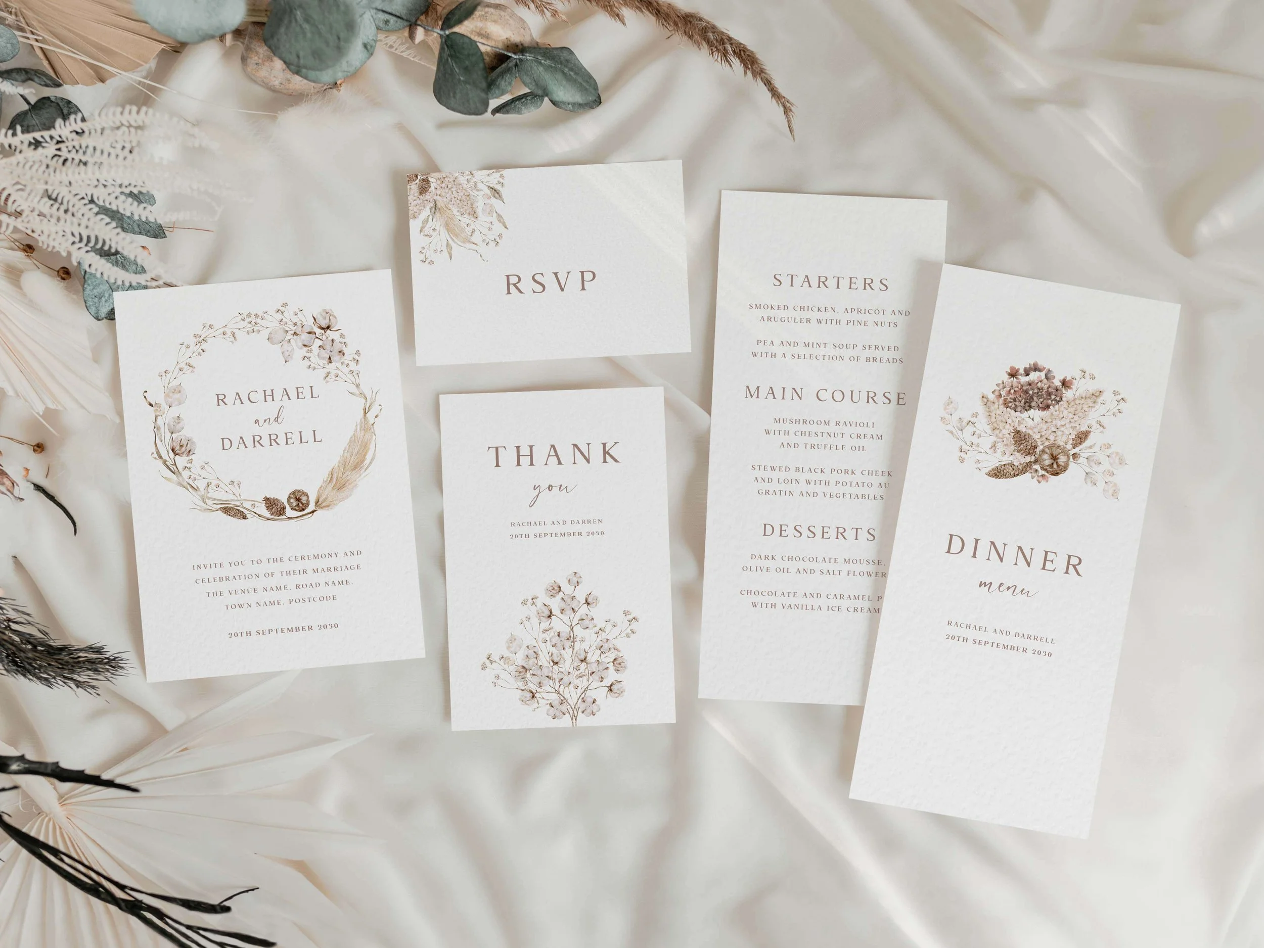 Full Boho wedding stationery suite flat lay showing invitations, RSVP cards and coordinating pieces with neutral dried flower botanical illustrations