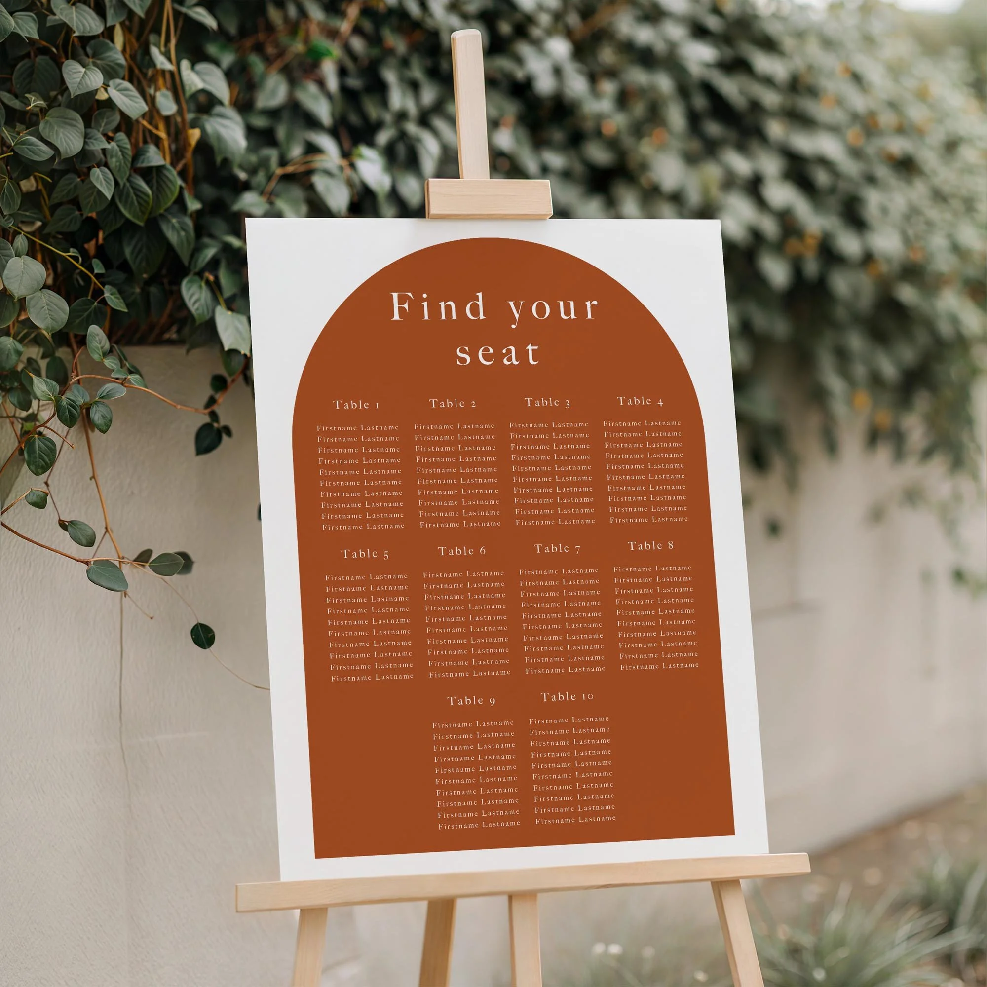 Close-up of the Burnt Orange Arch Shape Graphic wedding seating plan board displayed outdoors