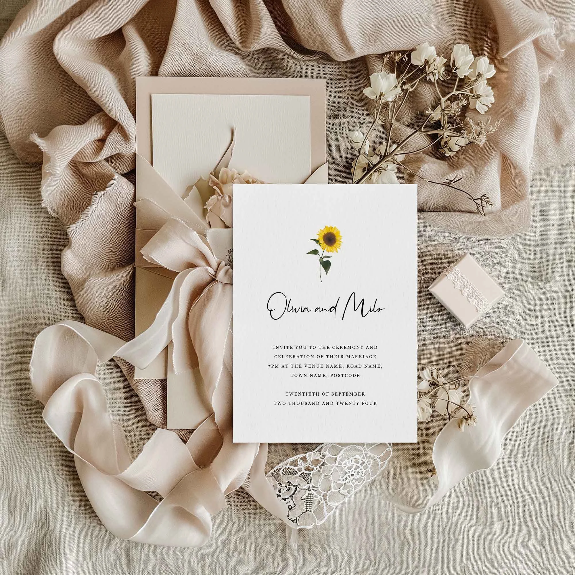Simple Sunflower wedding invitation styled in a flat lay environment with wedding props