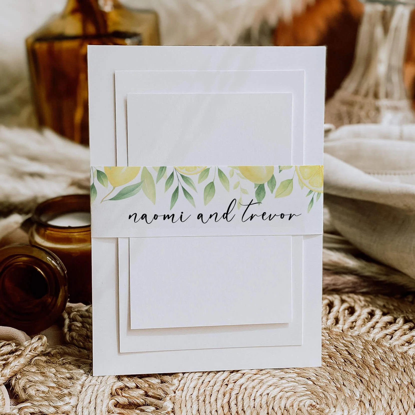 Lemon wedding belly band with Mediterranean citrus illustrations and personalised handwritten script wrapped around wedding invitations
