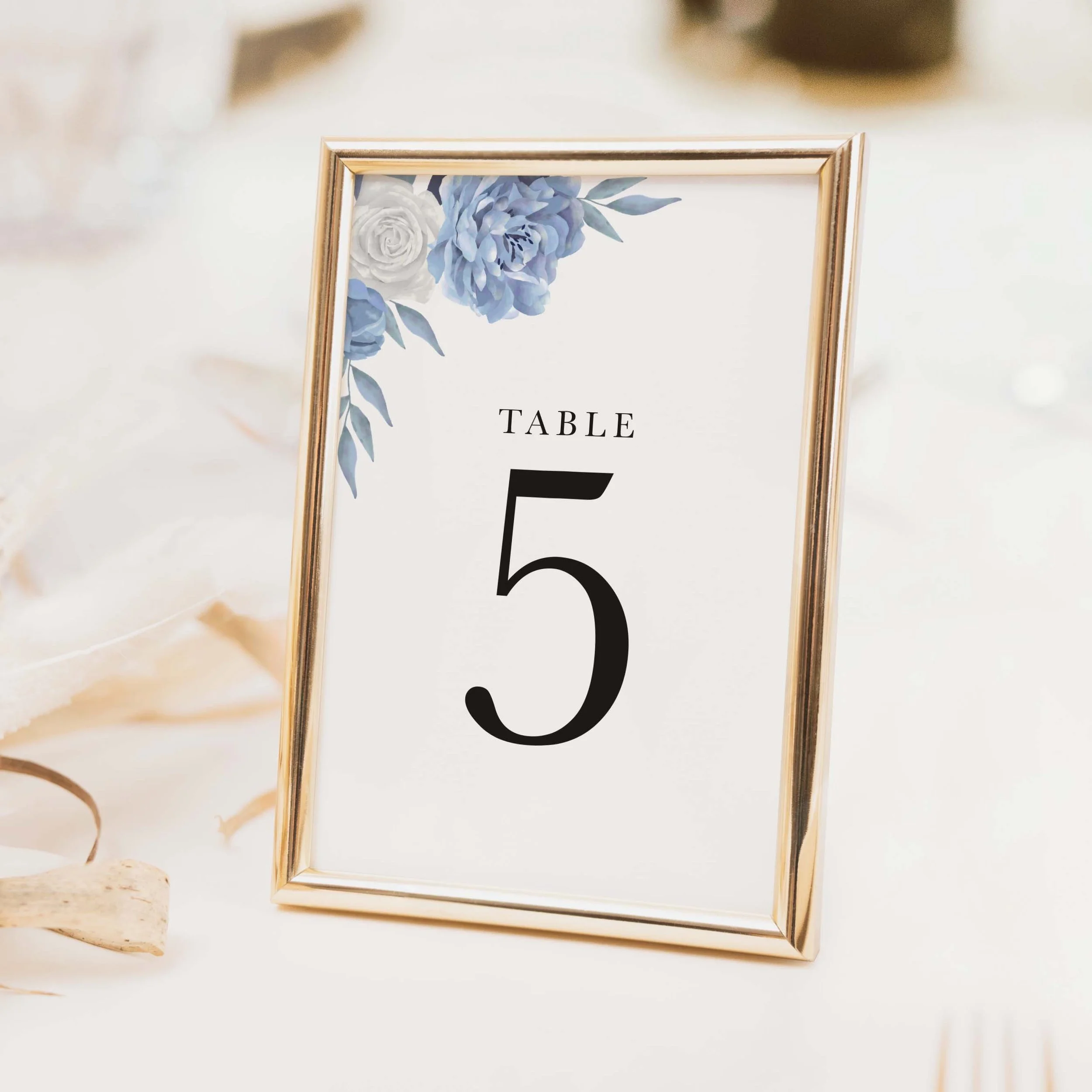 Blossom wedding table number with delicate blue floral sprig illustration and bold modern serif typography printed on luxury off-white textured card