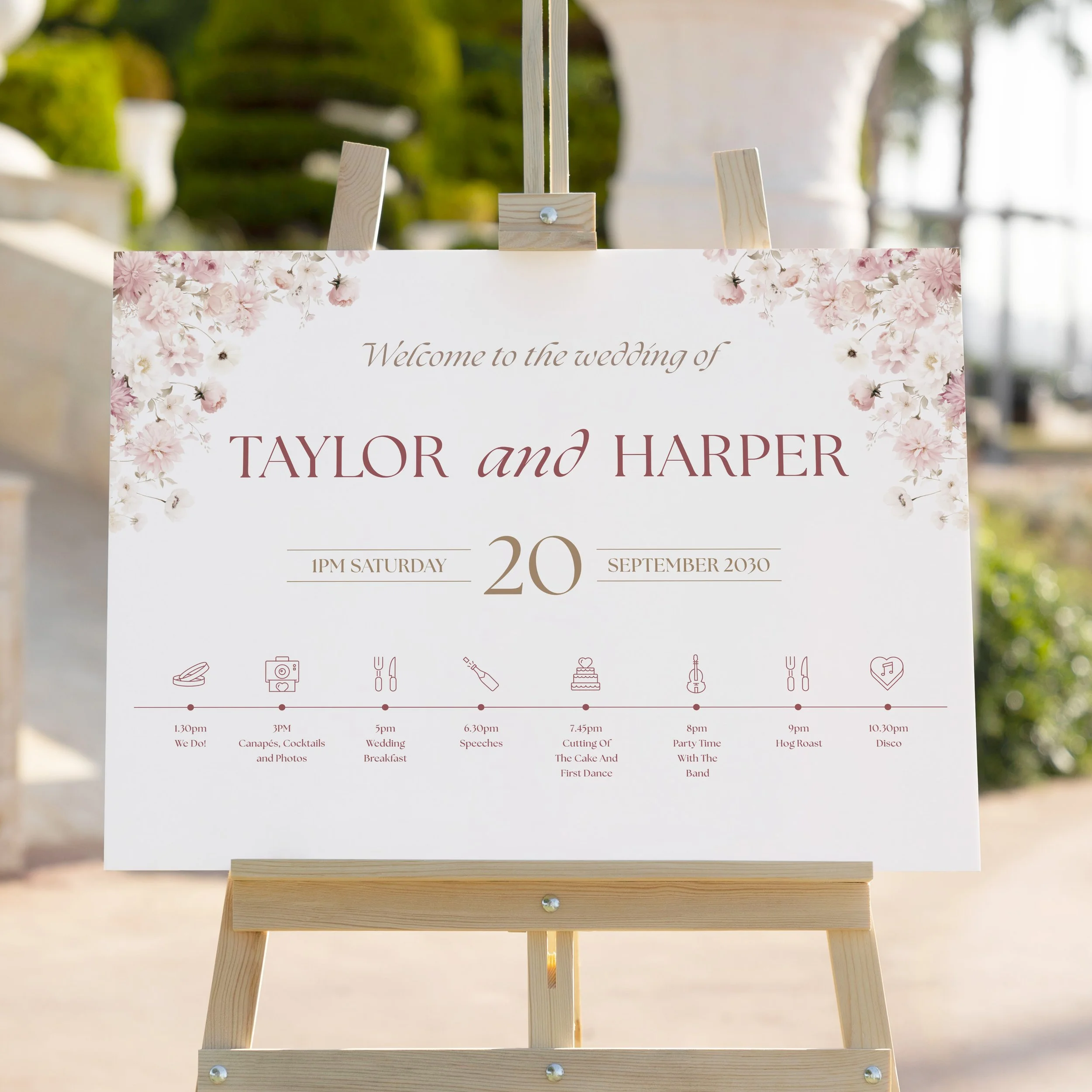 Close-up of Petal Wedding Welcome Sign on easel showing blush pink florals and timeline.