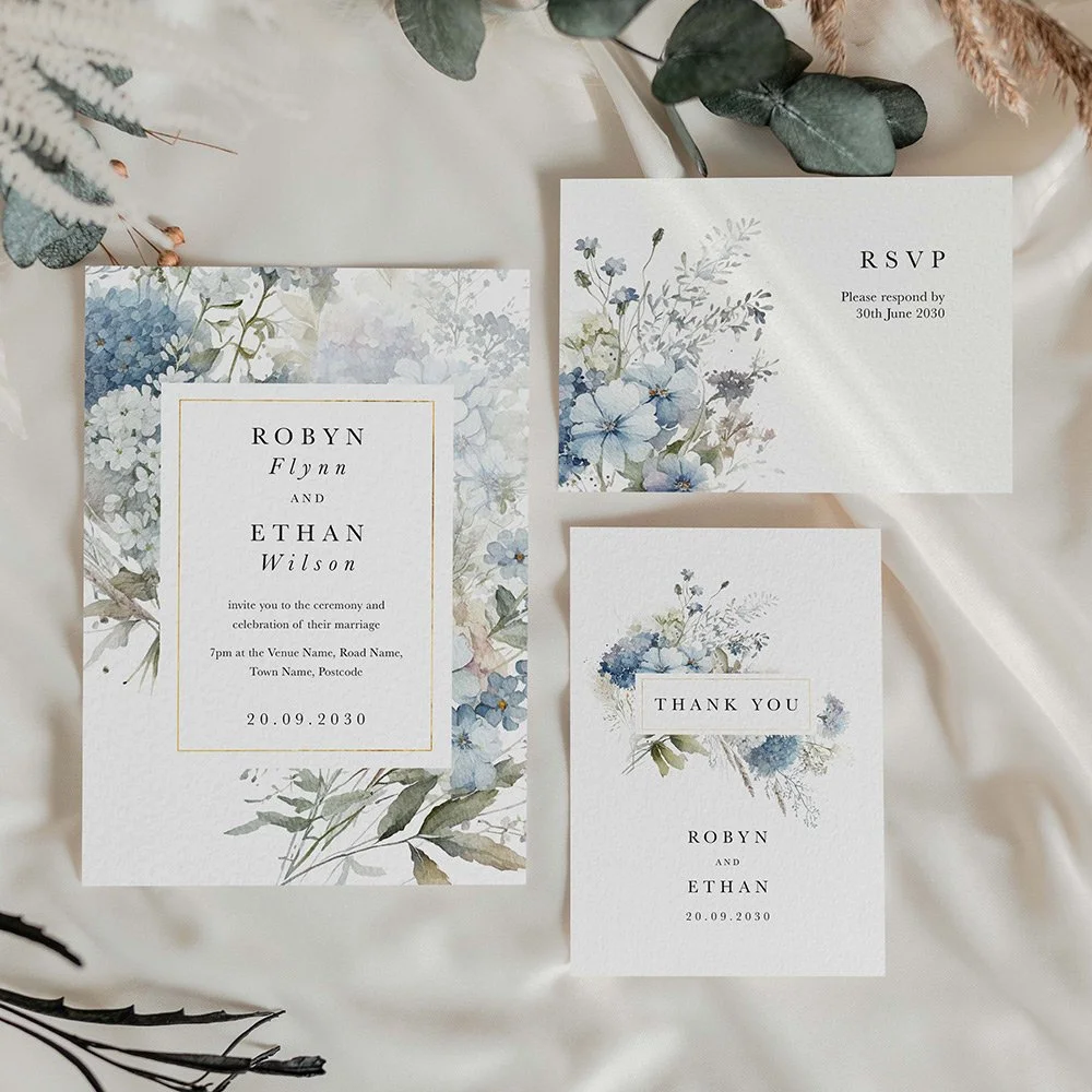 Dusty Blue Collection flat wedding invitation with matching RSVP and thank you cards, featuring delicate blue wildflowers and modern typography.