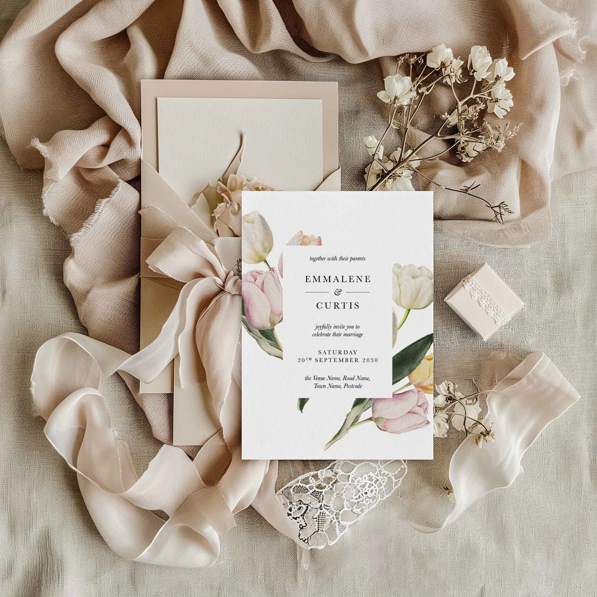 Pink, White, and Yellow Tulip wedding invitation styled in a flat lay environment with wedding props