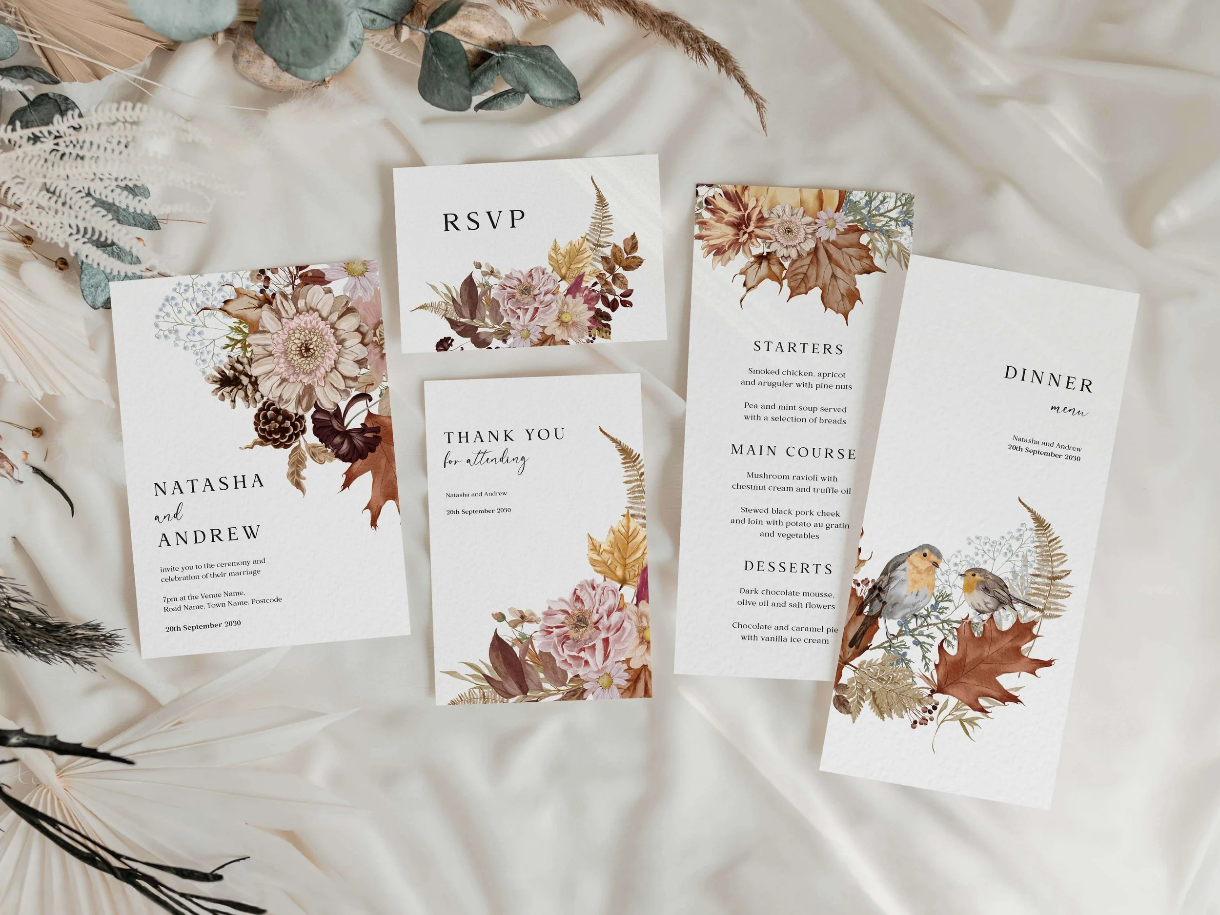 Full Autumn wedding stationery suite flat lay showing invitations, RSVP cards and coordinating pieces with rich autumn botanical floral design