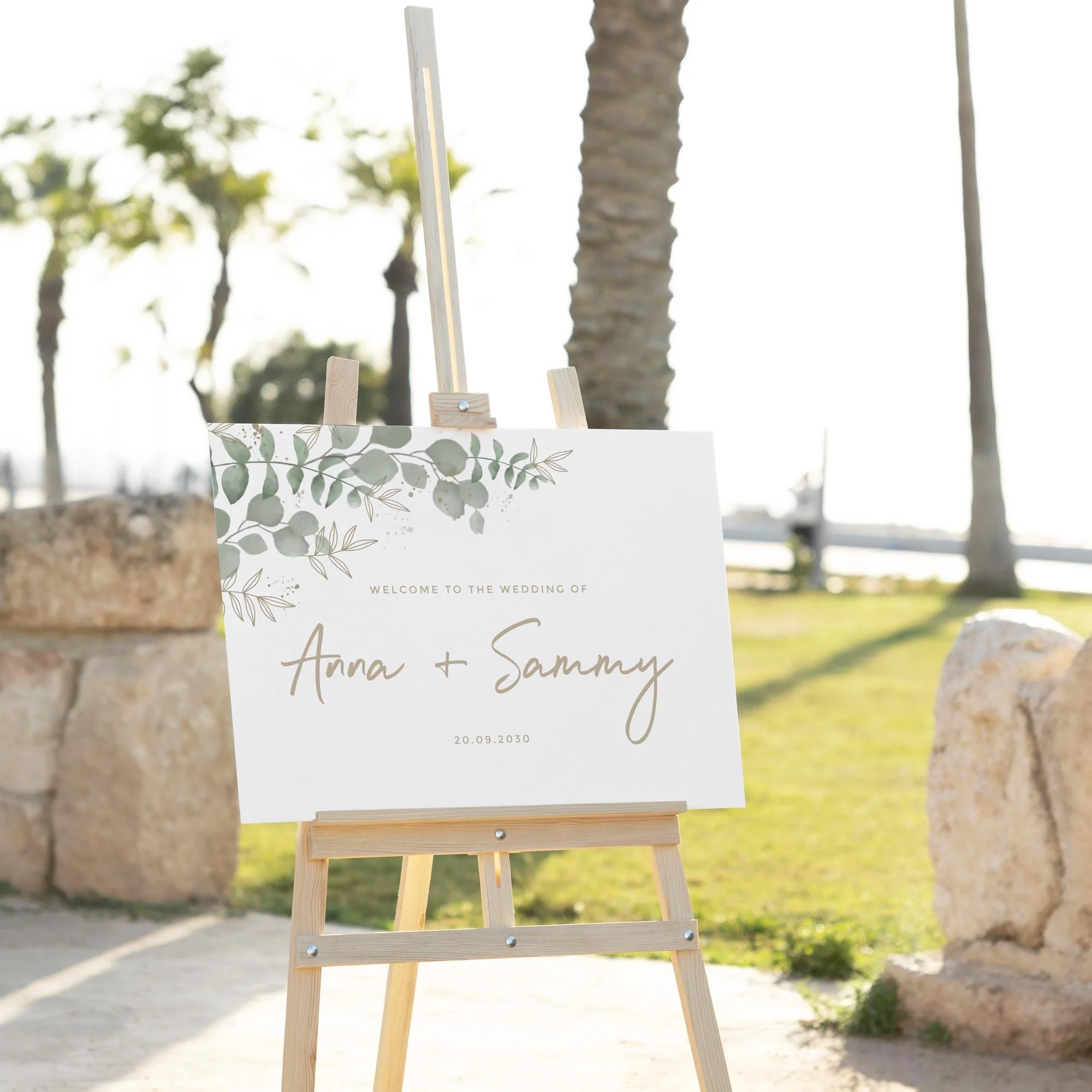 Modern Eucalyptus wedding welcome sign displayed outdoors at a wedding venue on an easel