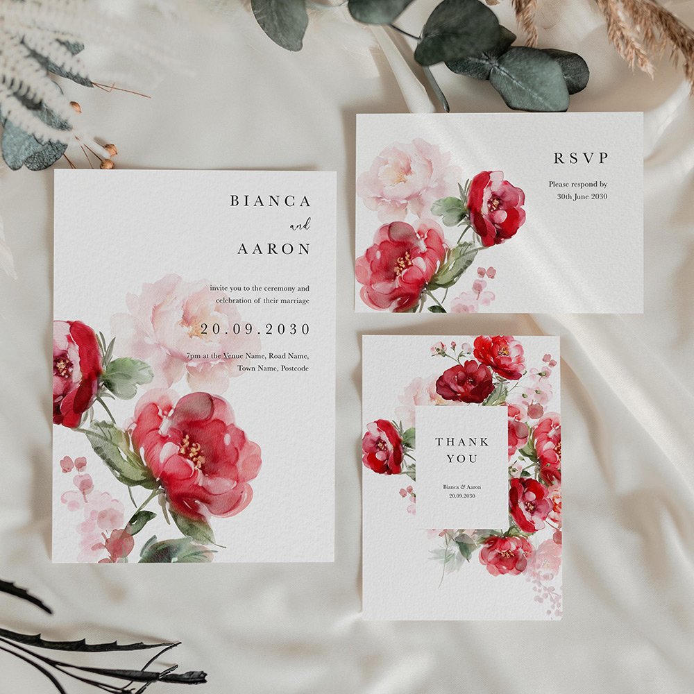 Wedding stationery cards featuring red and blush pink watercolour florals with modern serif and script typography on a white background.