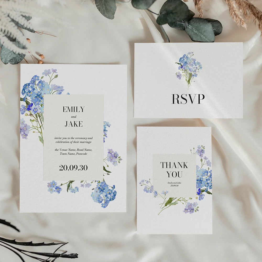 Forget-me-not wedding stationery set including Invitation, RSVP card, and thank you card with blue florals and cream oval text area.