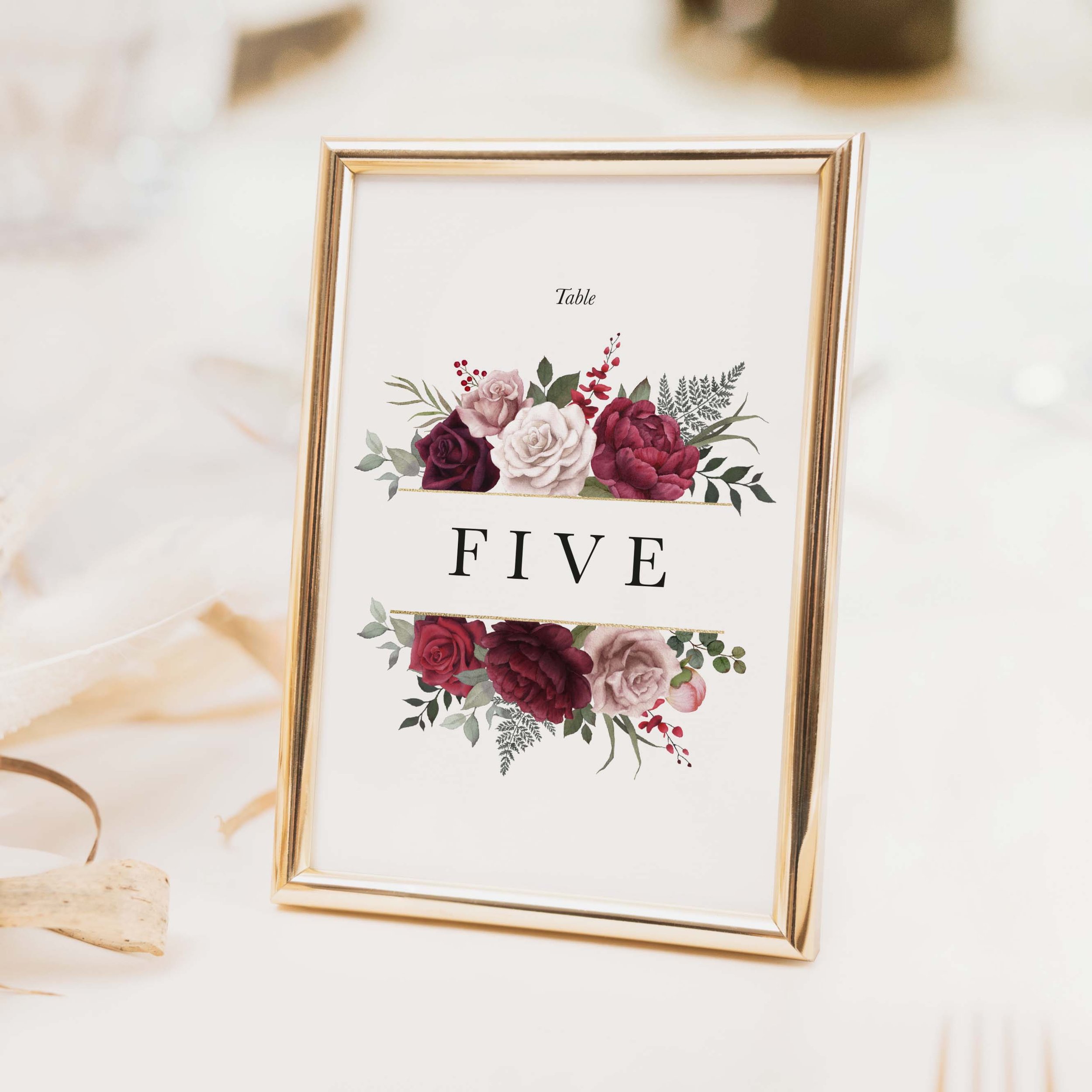 Romance wedding table number with deep burgundy wine and pink floral arrangement and bold elegant typography on luxury off-white card
