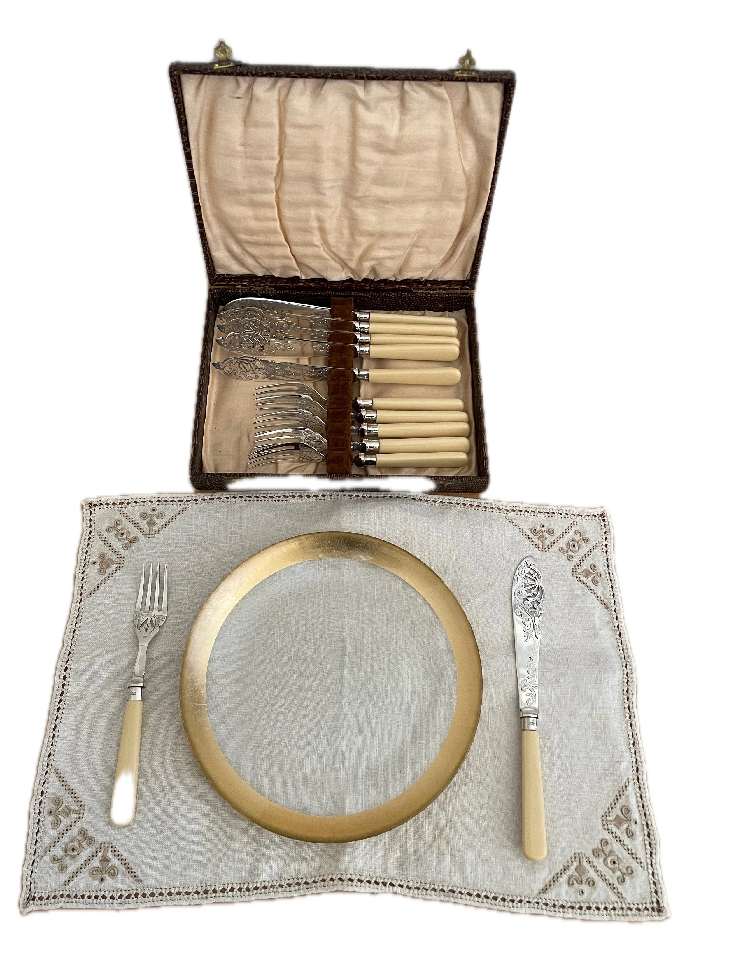 An elegant vintage set of silver plate fish cutlery — with “French Ivory” handles, sterling silver bands, and intricate engravings typical of Victorian or Edwardian styles — are displayed in a silk-lined presentation box. Originally purchased at auct