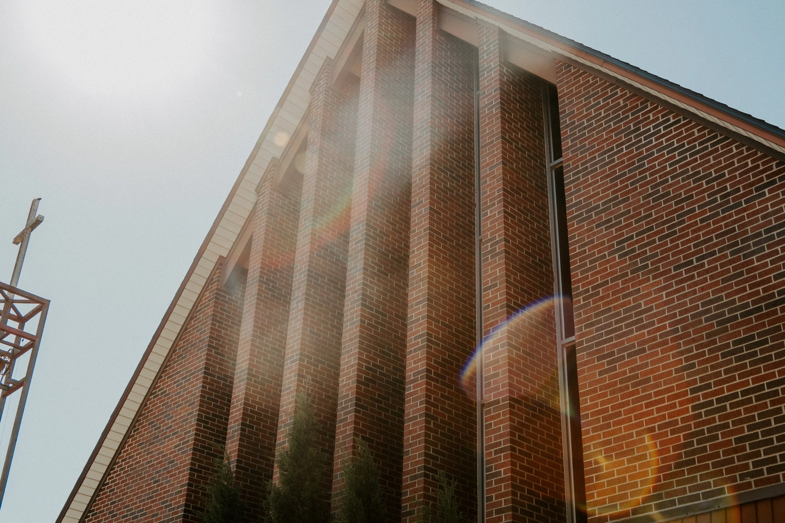 Close-up of a modern brick church building with tall, narrow windows under a clear, sunny sky